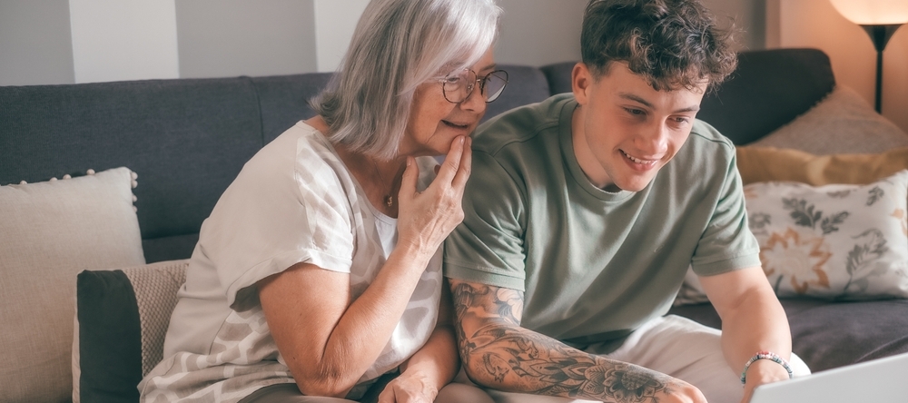 Grandmother and grandson sitting in front of laptop.