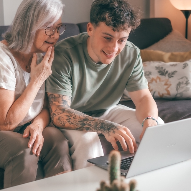 Grandmother and grandson sitting in front of laptop.