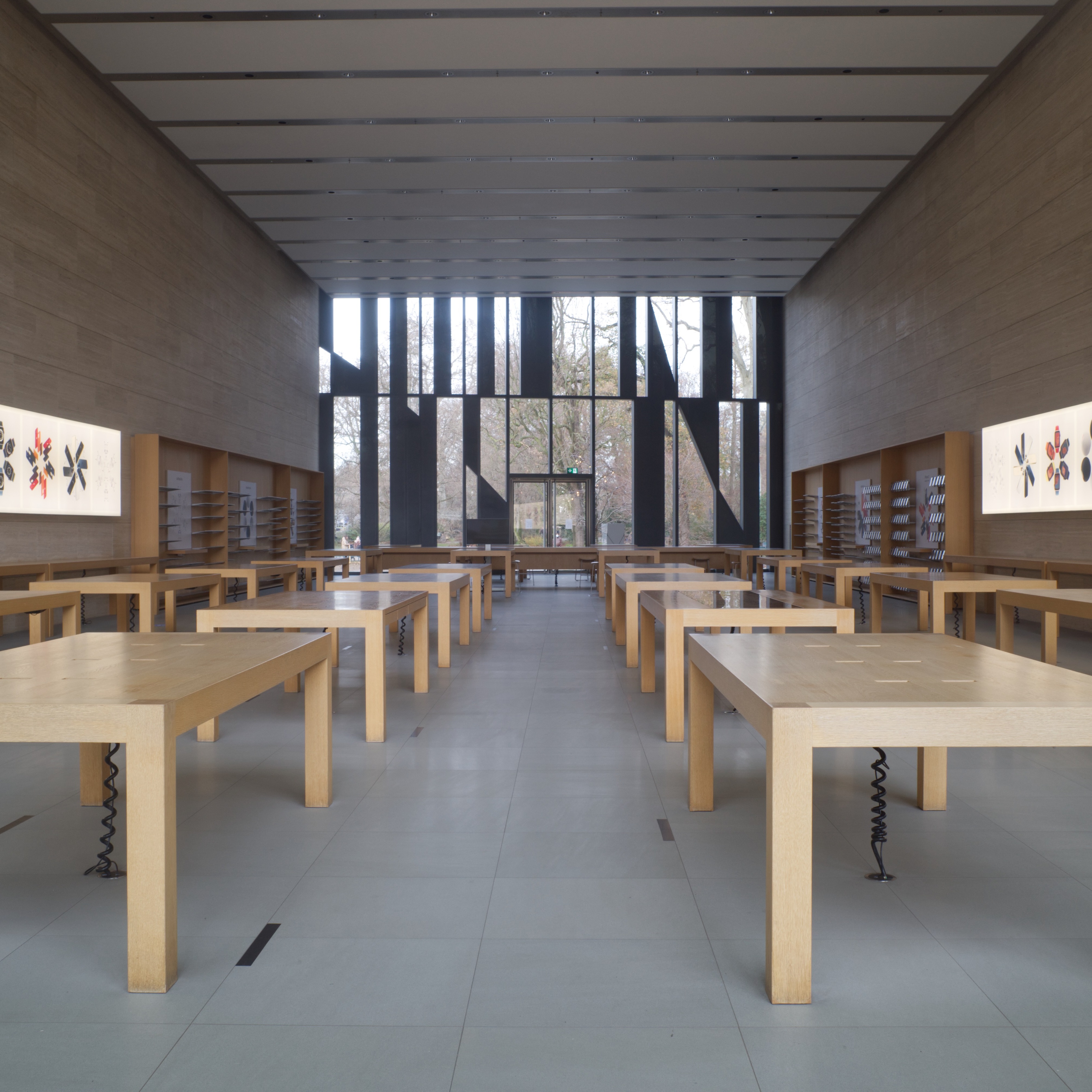 The interior view of an empty Apple Store location with no products on the tables or walls.