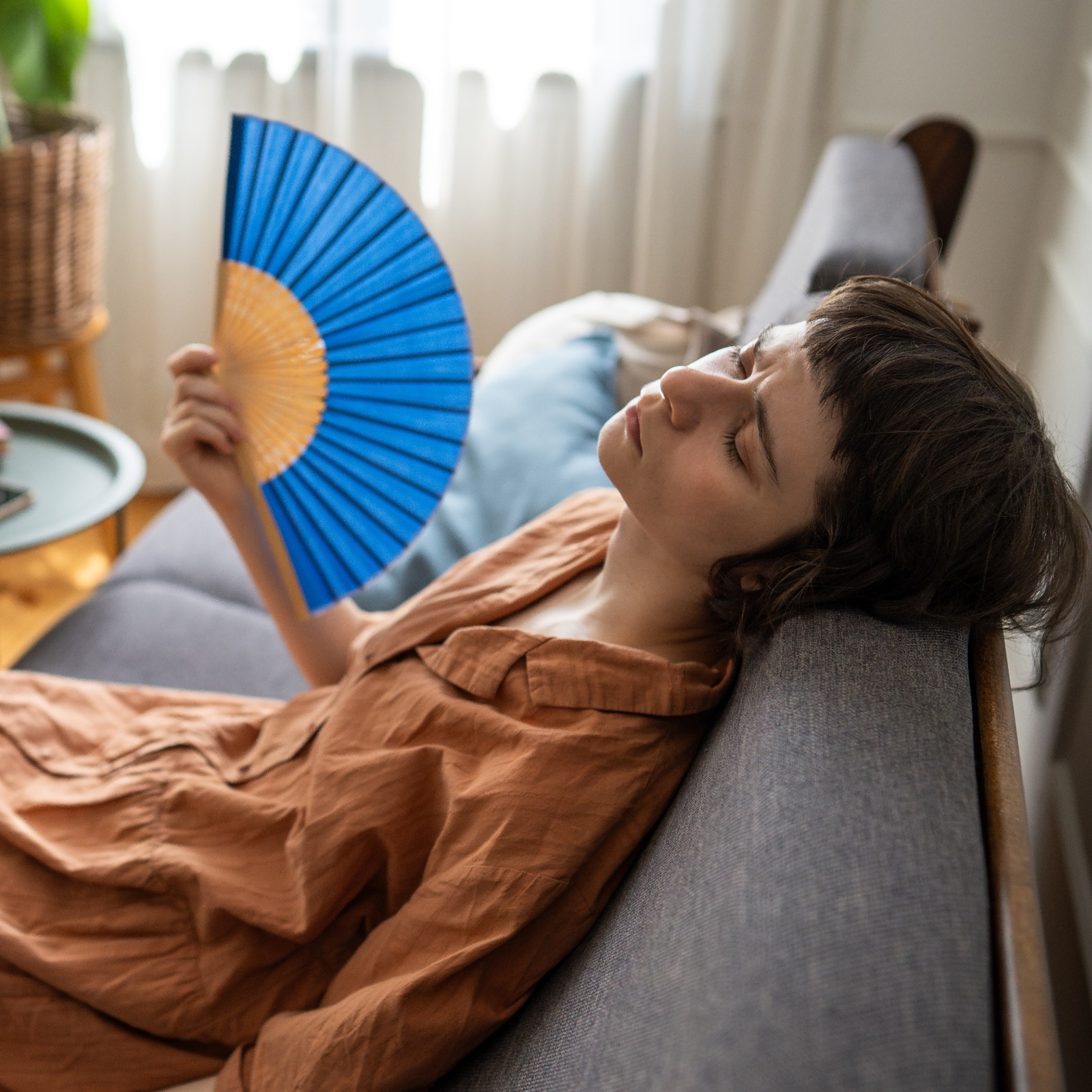 woman hot in apartment with fan and elon musk bubble