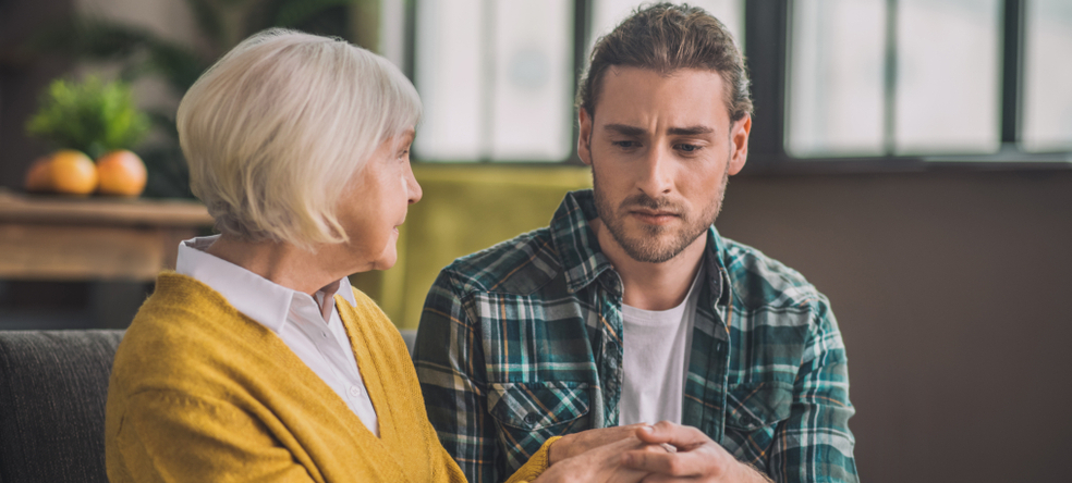Photo of a young man with an older woman, looking worried