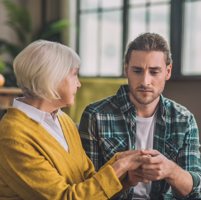 Photo of a young man with an older woman, looking worried