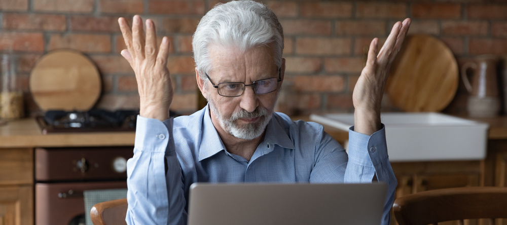 Frustrated man sitting in front of computer.
