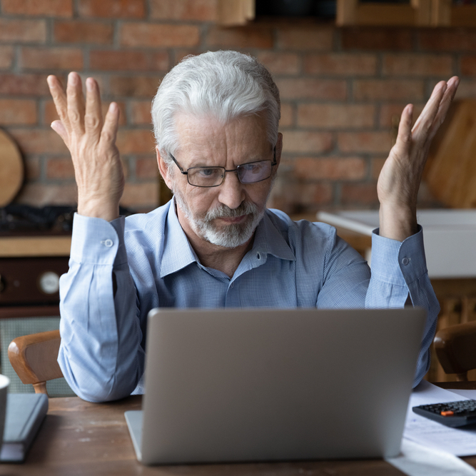 Frustrated man sitting in front of computer.