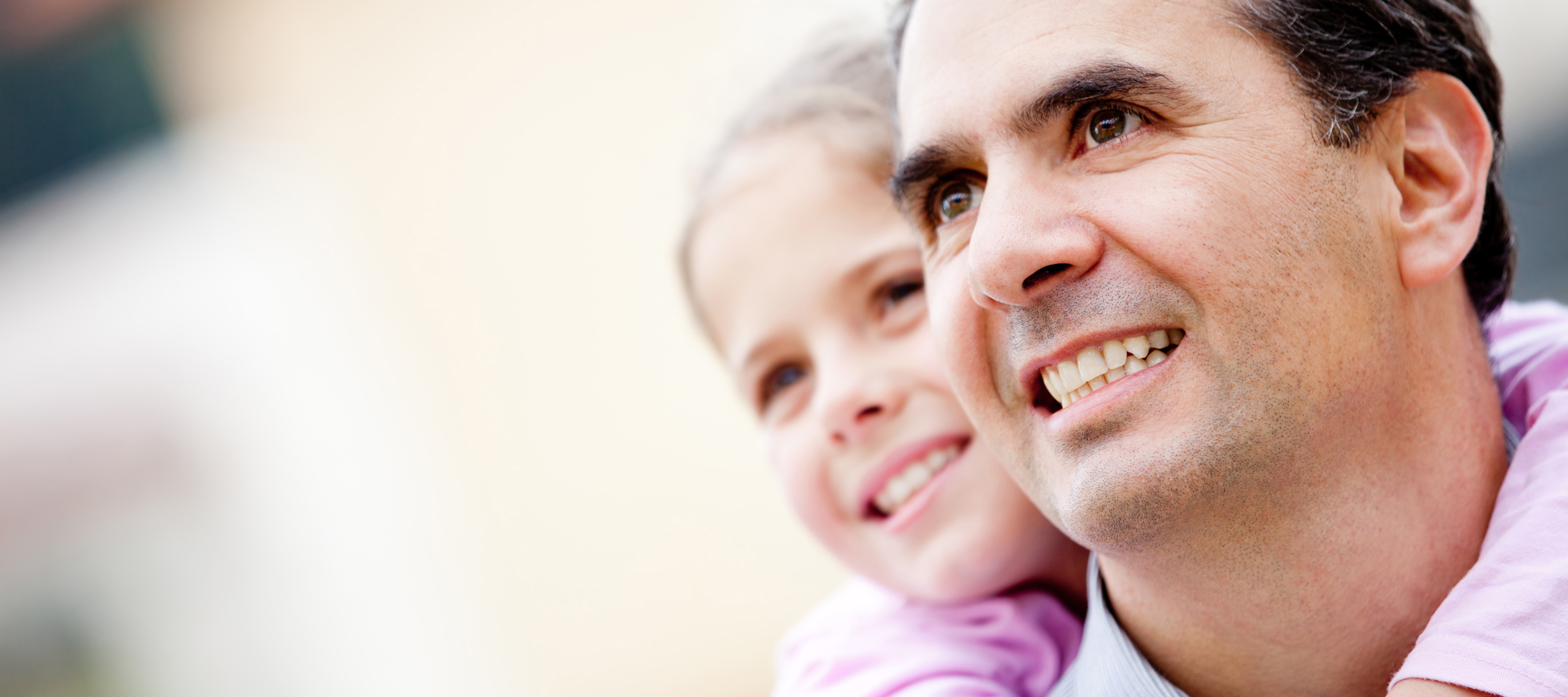 A father gives his daughter a piggyback ride.