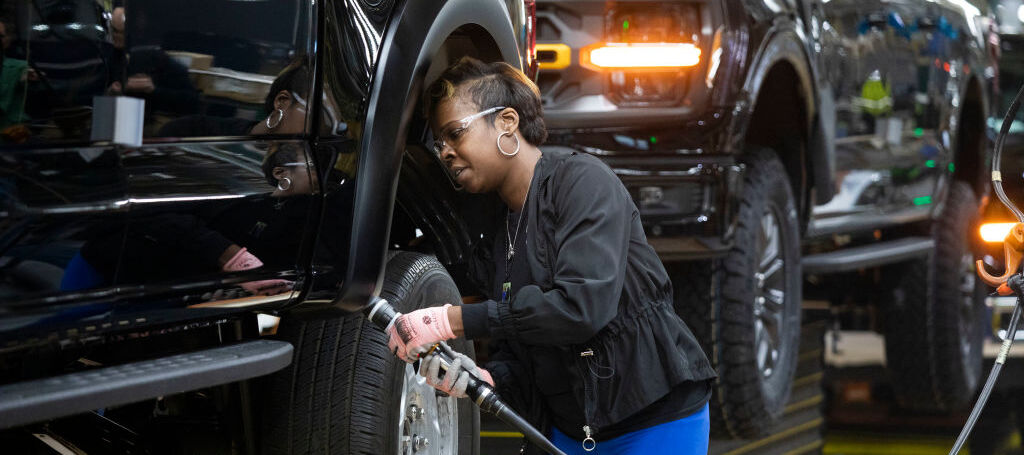 Ford worker LaShunta Harris works on a new Ford F-150 truck as it goes through the assembly line.
