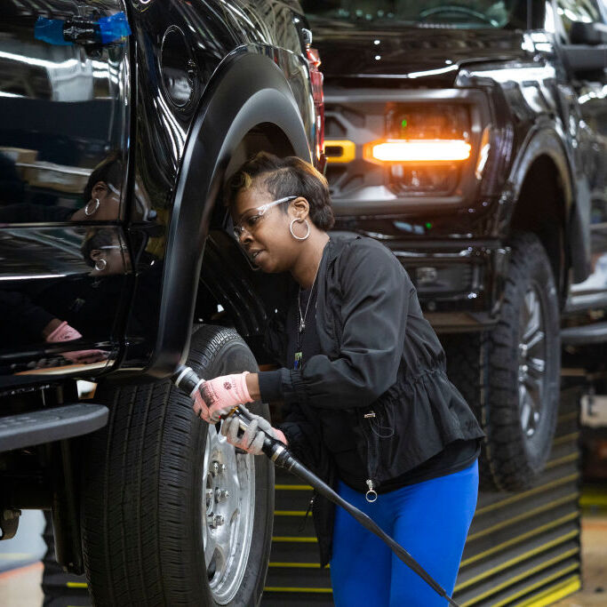 Ford worker LaShunta Harris works on a new Ford F-150 truck as it goes through the assembly line.