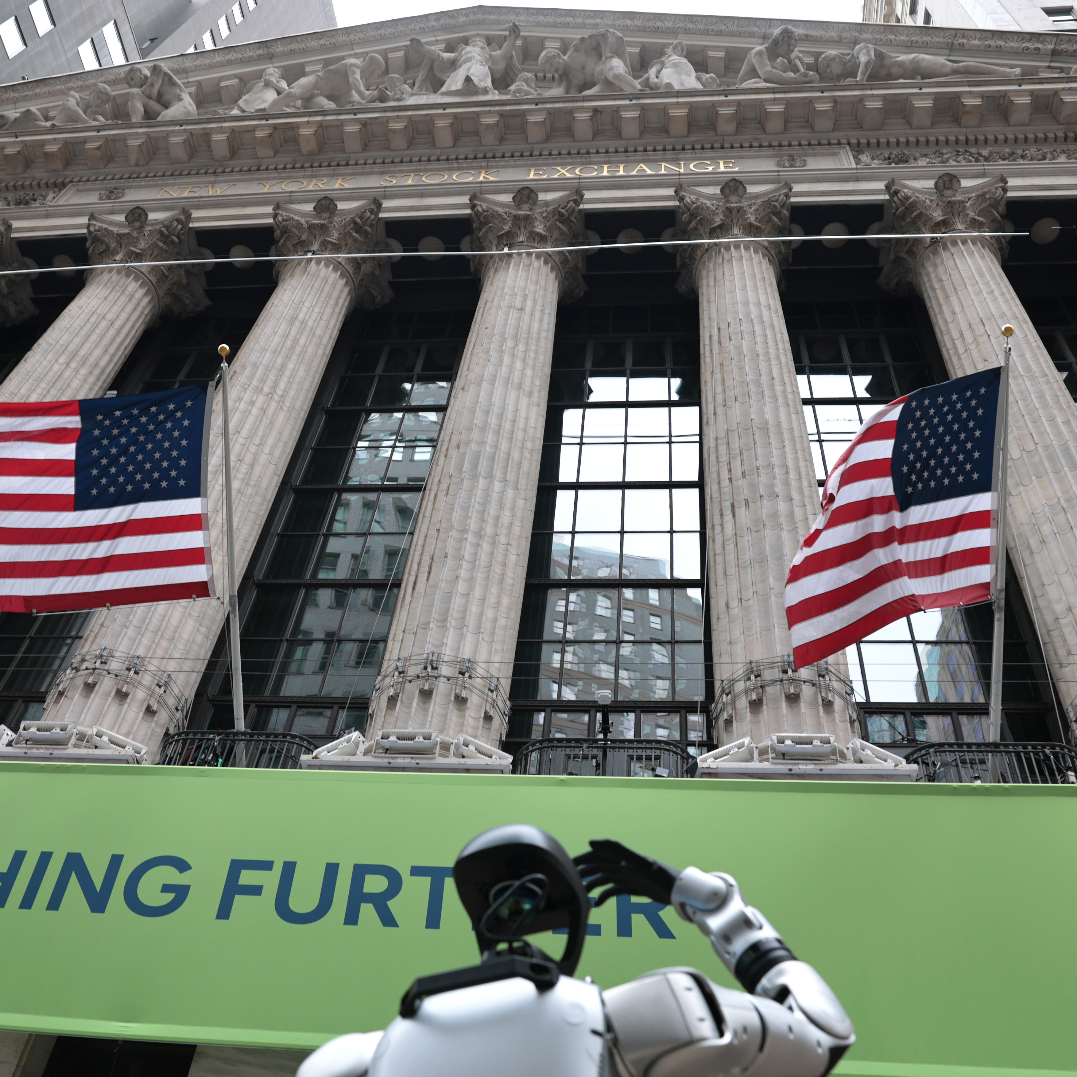 A Robostore robot does tricks for passersby in front of The New York Stock Exchange in 2025.