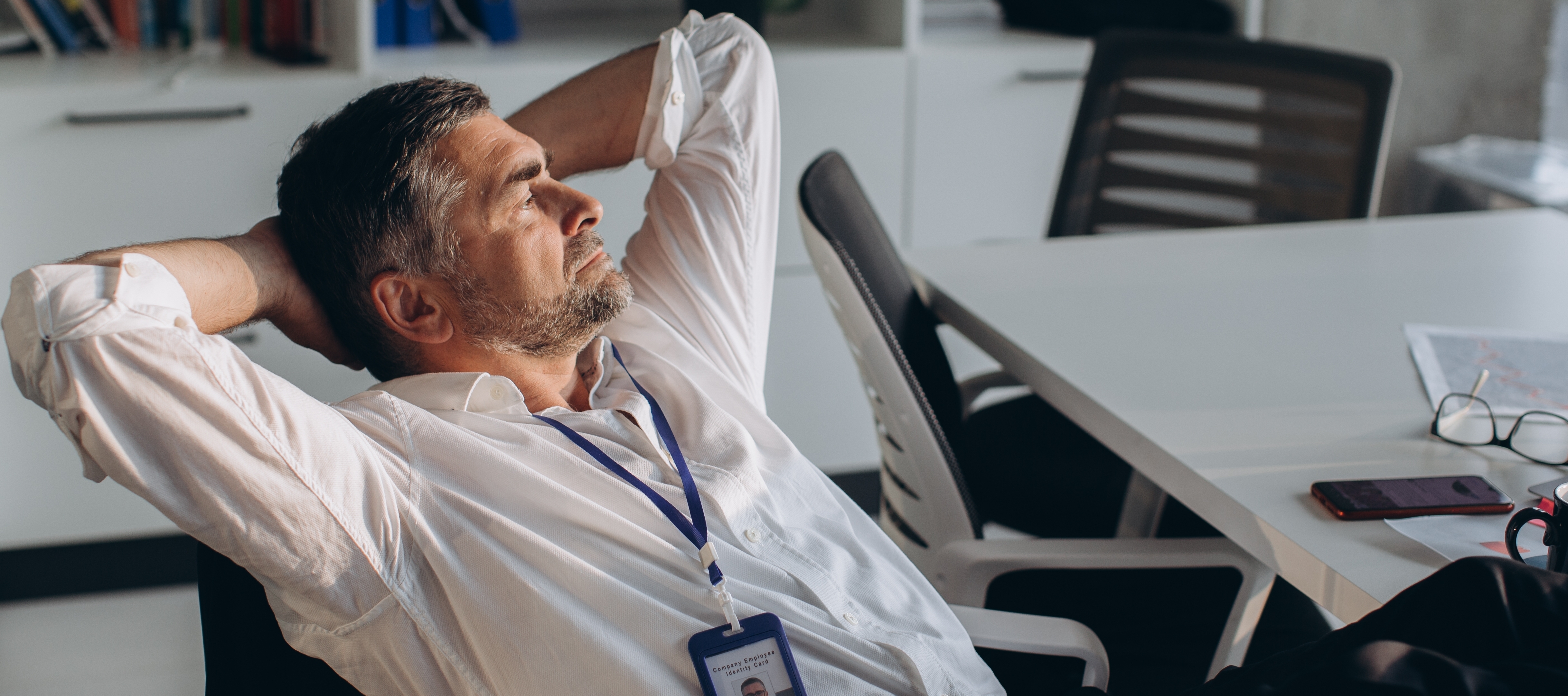 An older man leans back in his chair, considering his future.