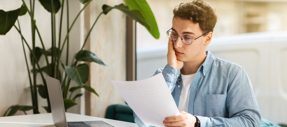 Confused man looking at documents.