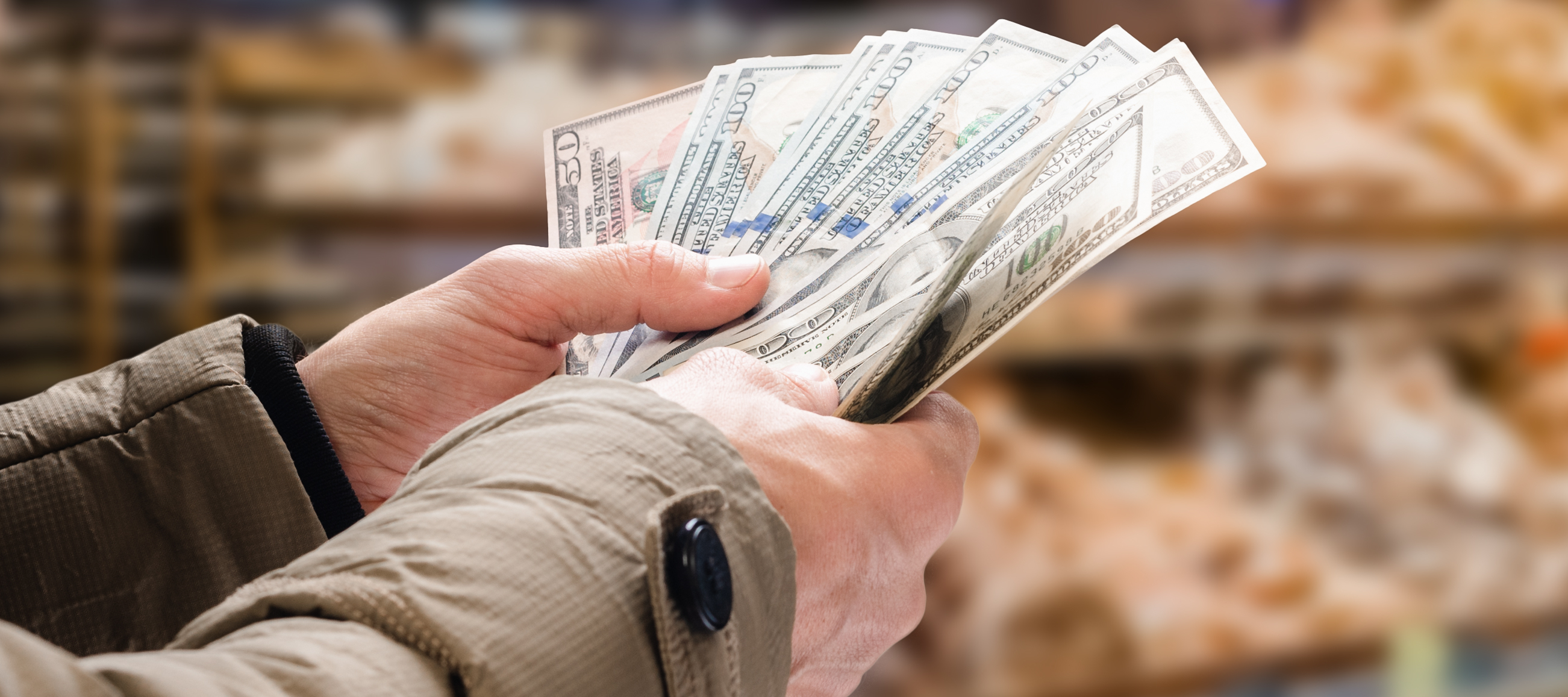 A man sorts through bills at the grocery store.