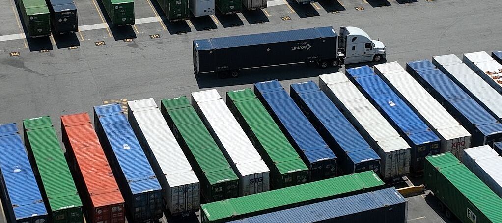 Shipping containers and cargo trucks on a lot.