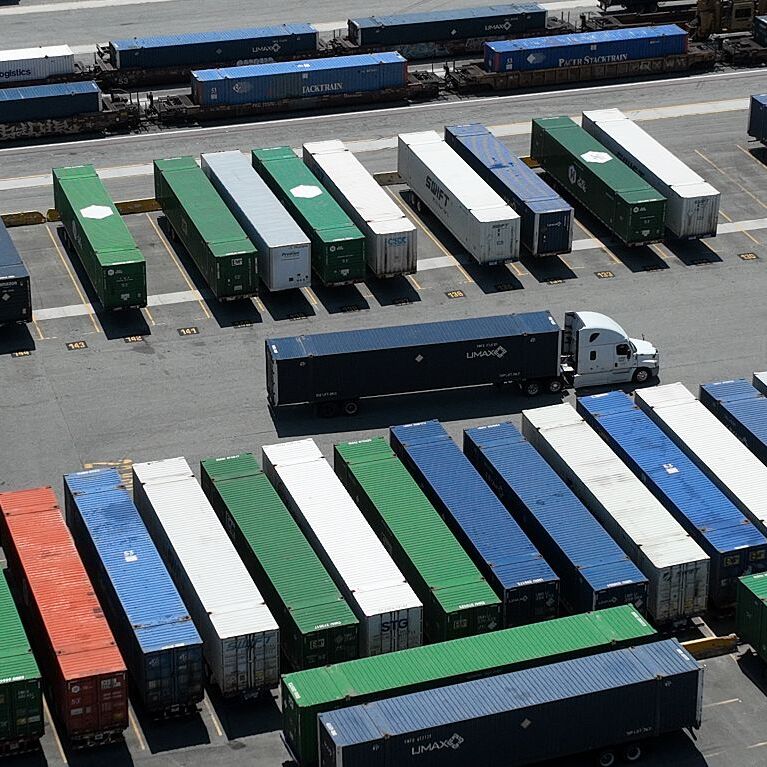 Shipping containers and cargo trucks on a lot.