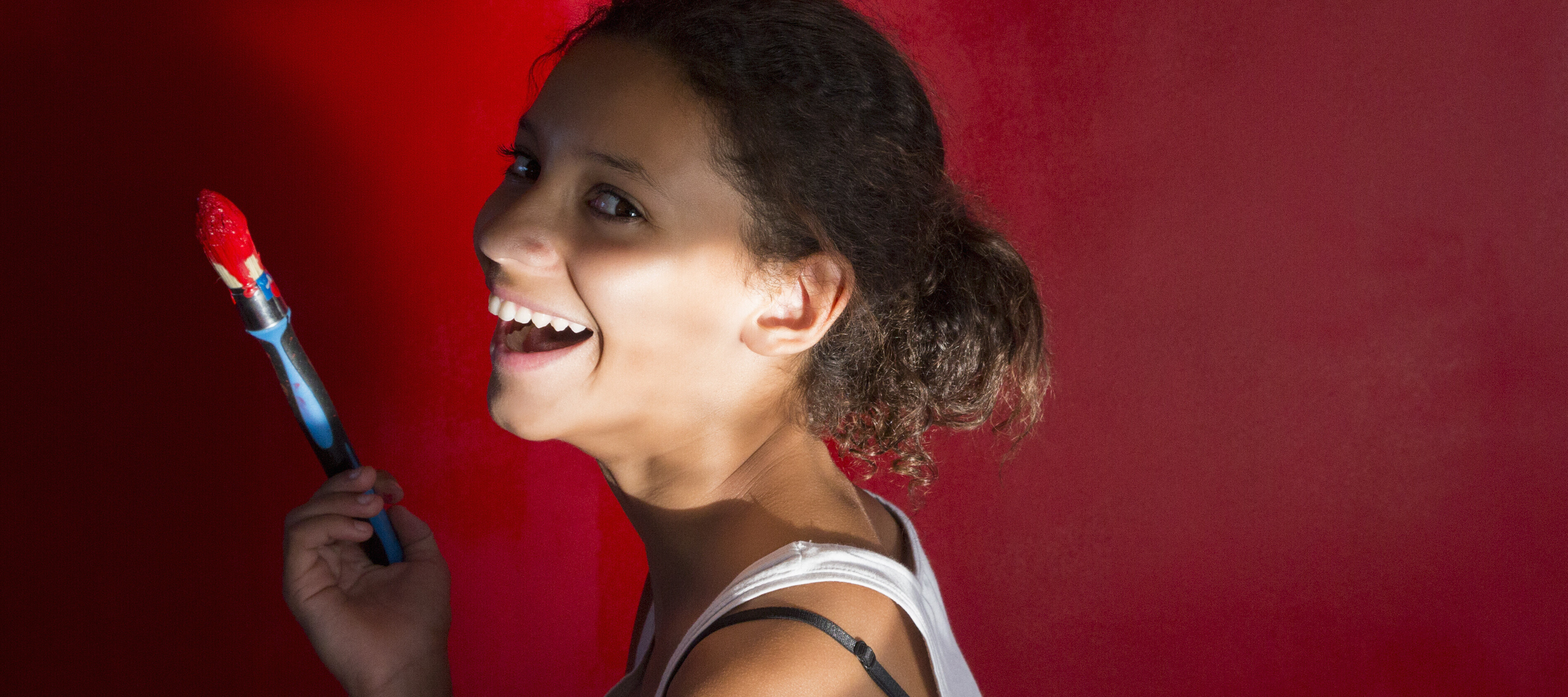 Young woman painting room red