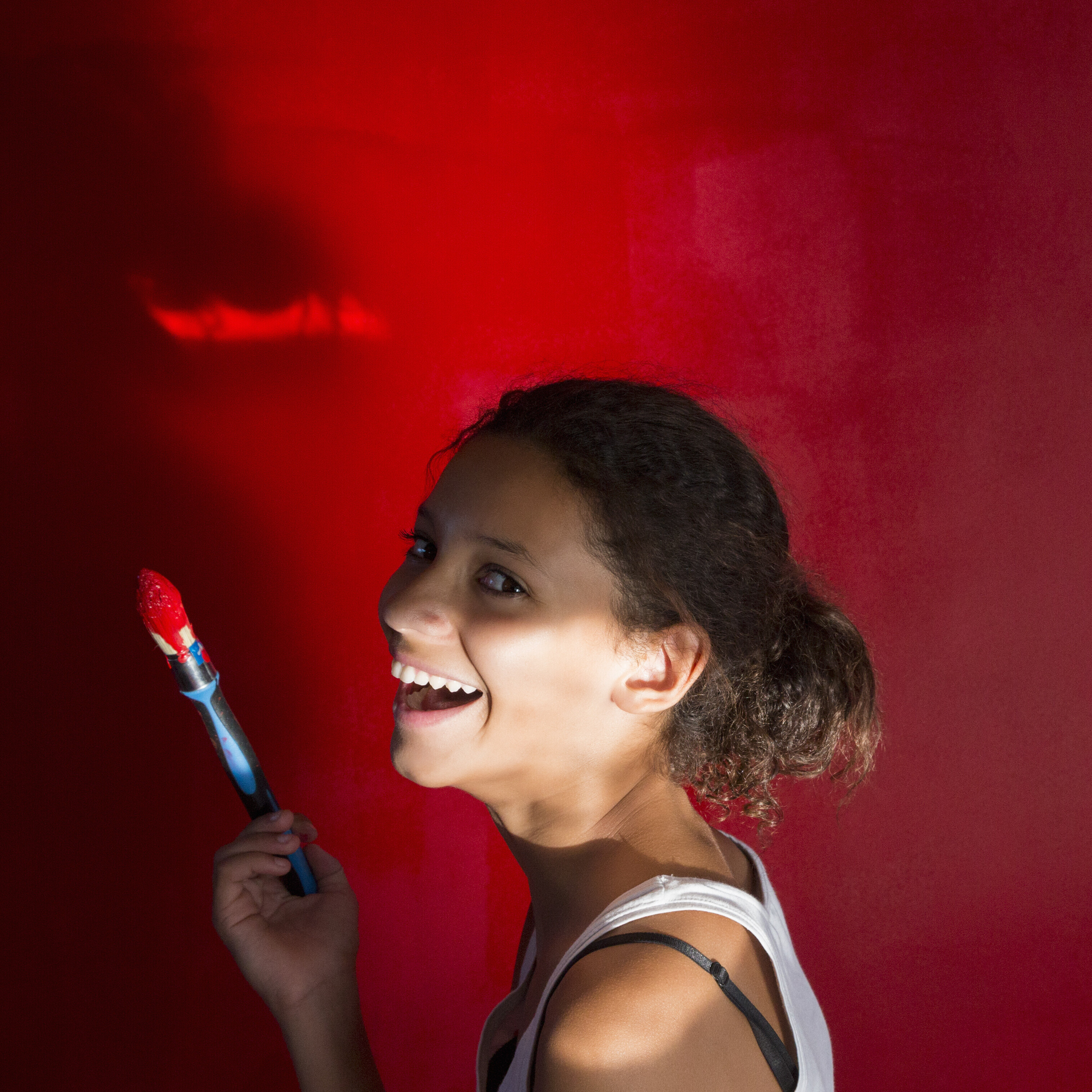 Young woman painting room red