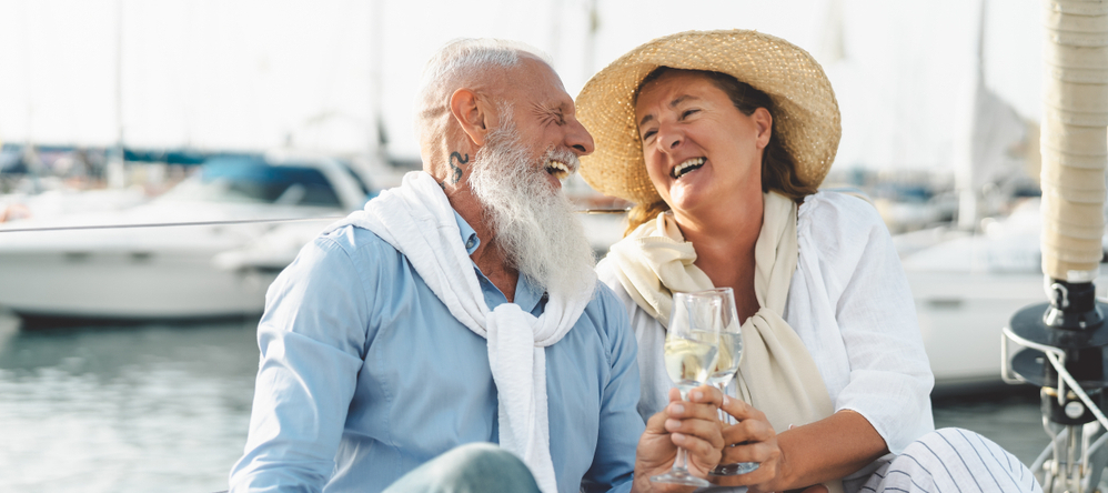 Wealthy couple laughing on a yacht.