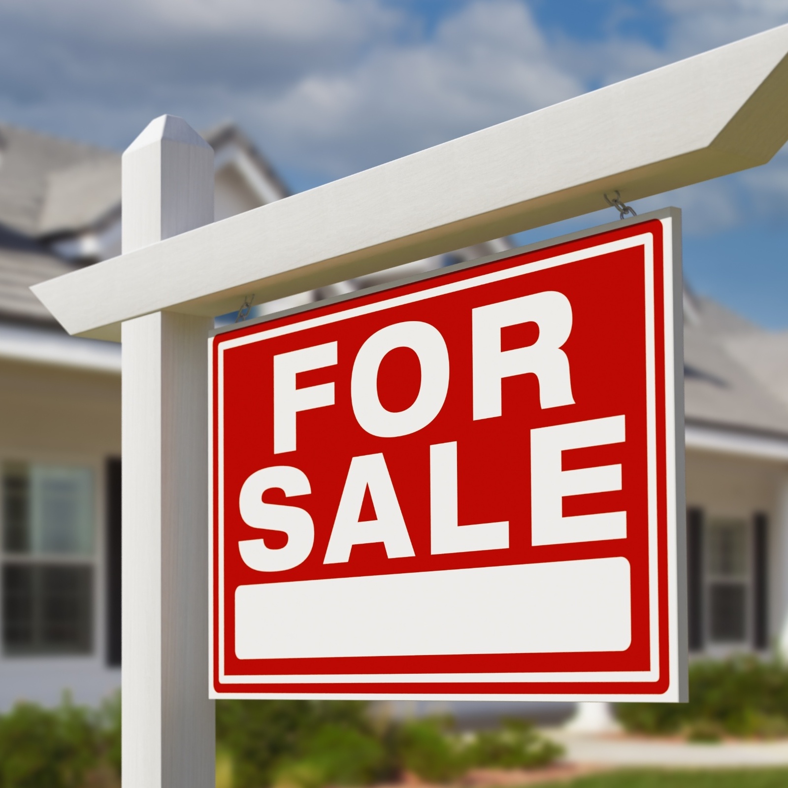 A big red "For Sale" sign out in front of a house