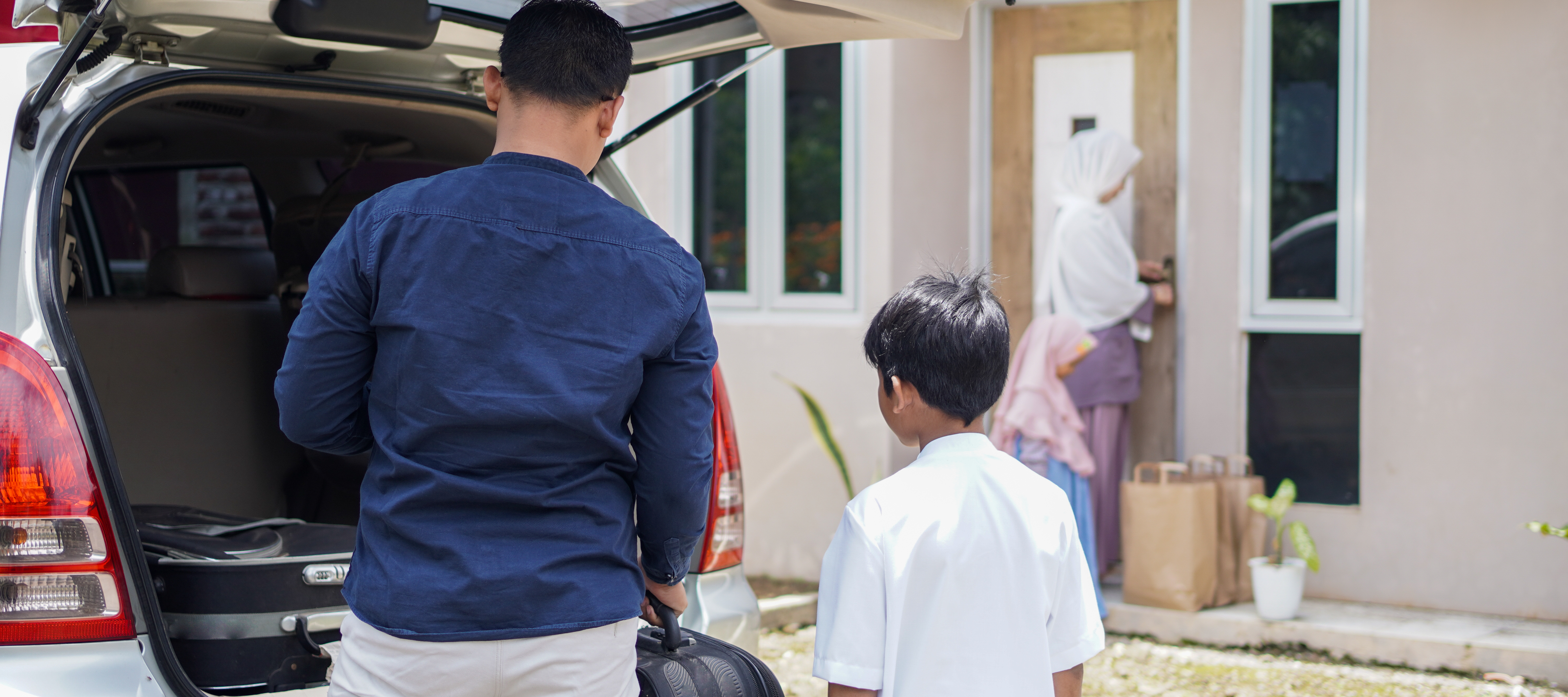 family coming home from shopping at front of house