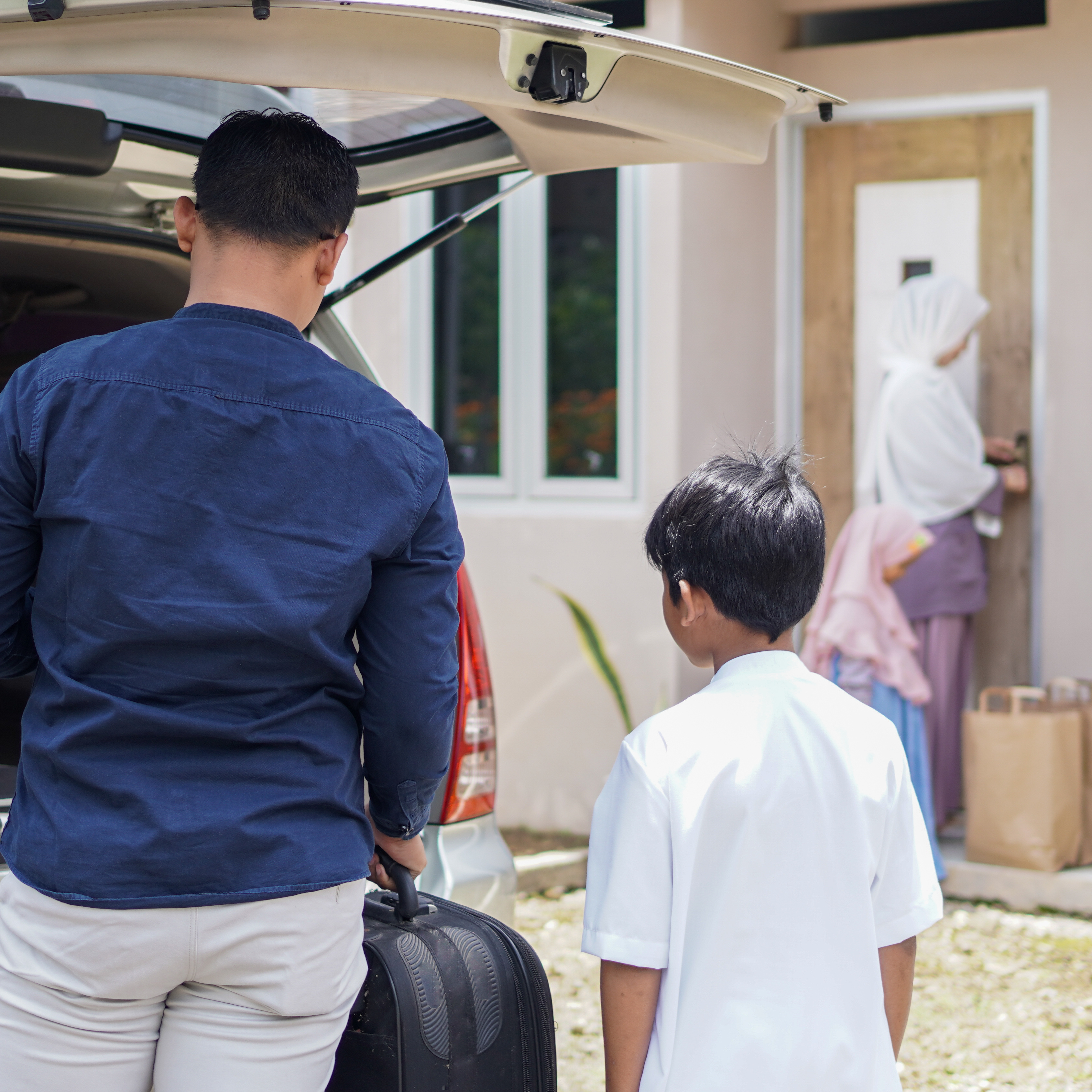 family coming home from shopping at front of house