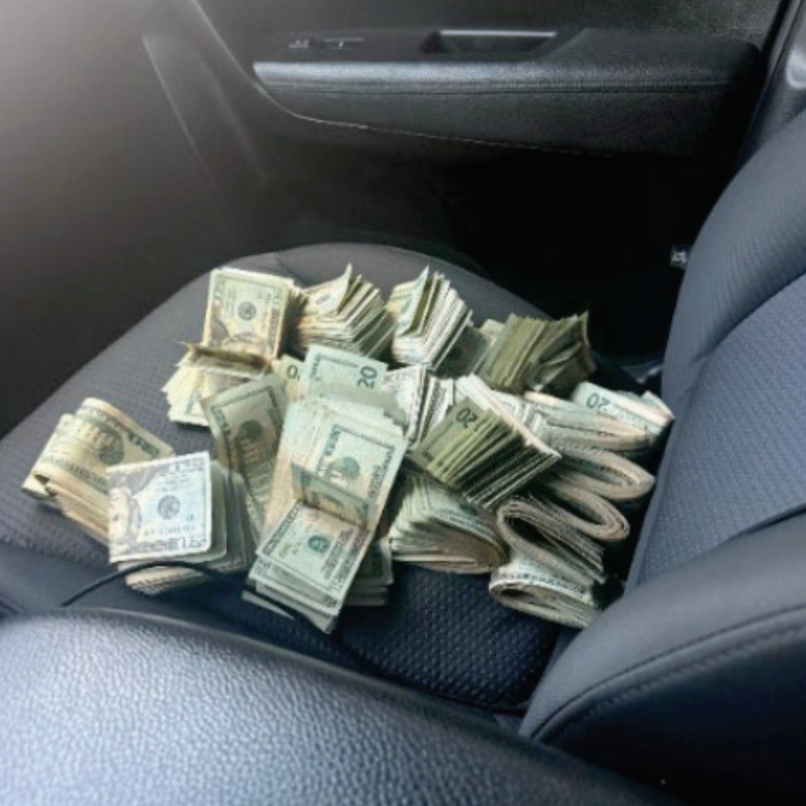 Images included in the indictment, allegedly taken from the suspects' phones, show large amounts of cash in piles on the floor.