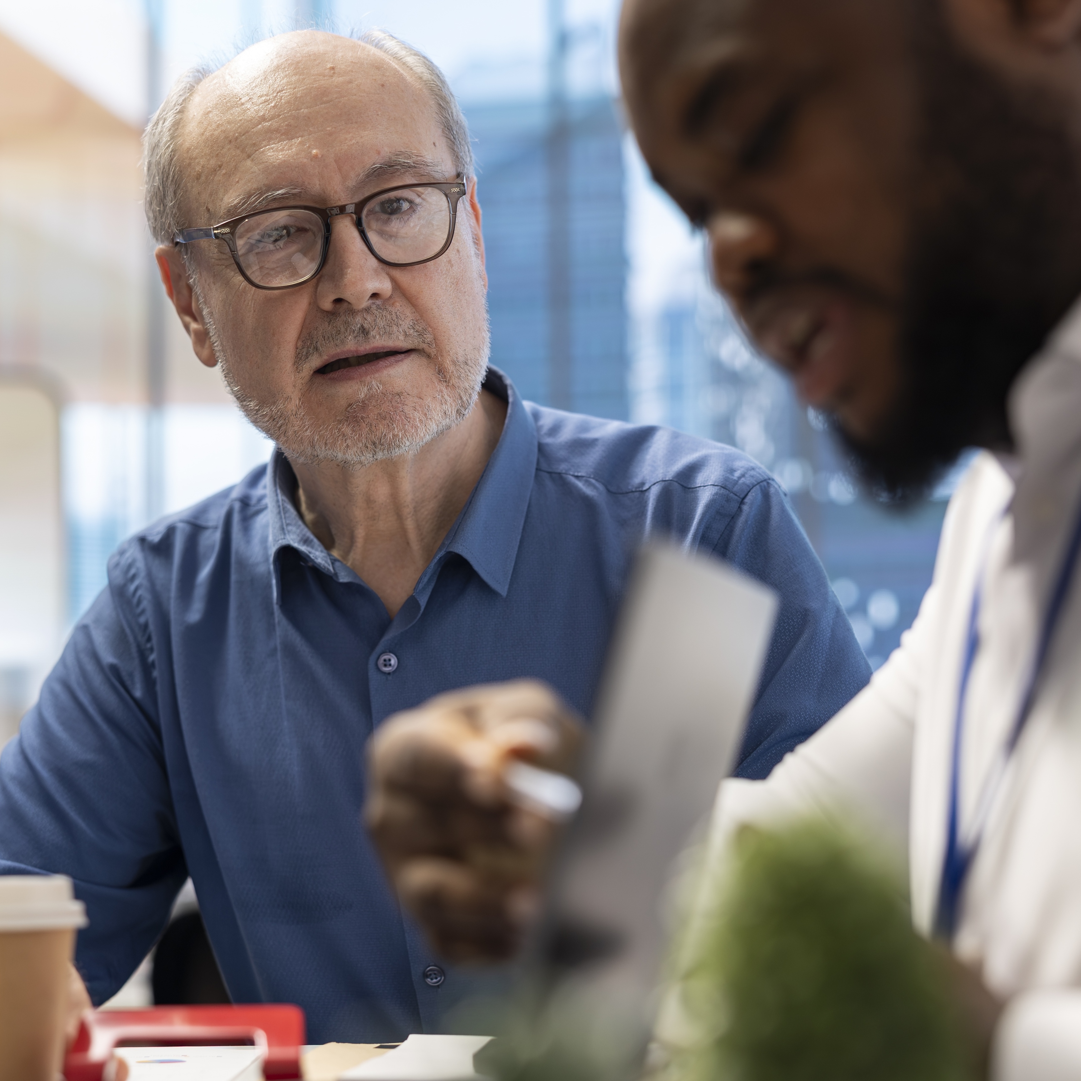 Perplexed older man speaking with younger man