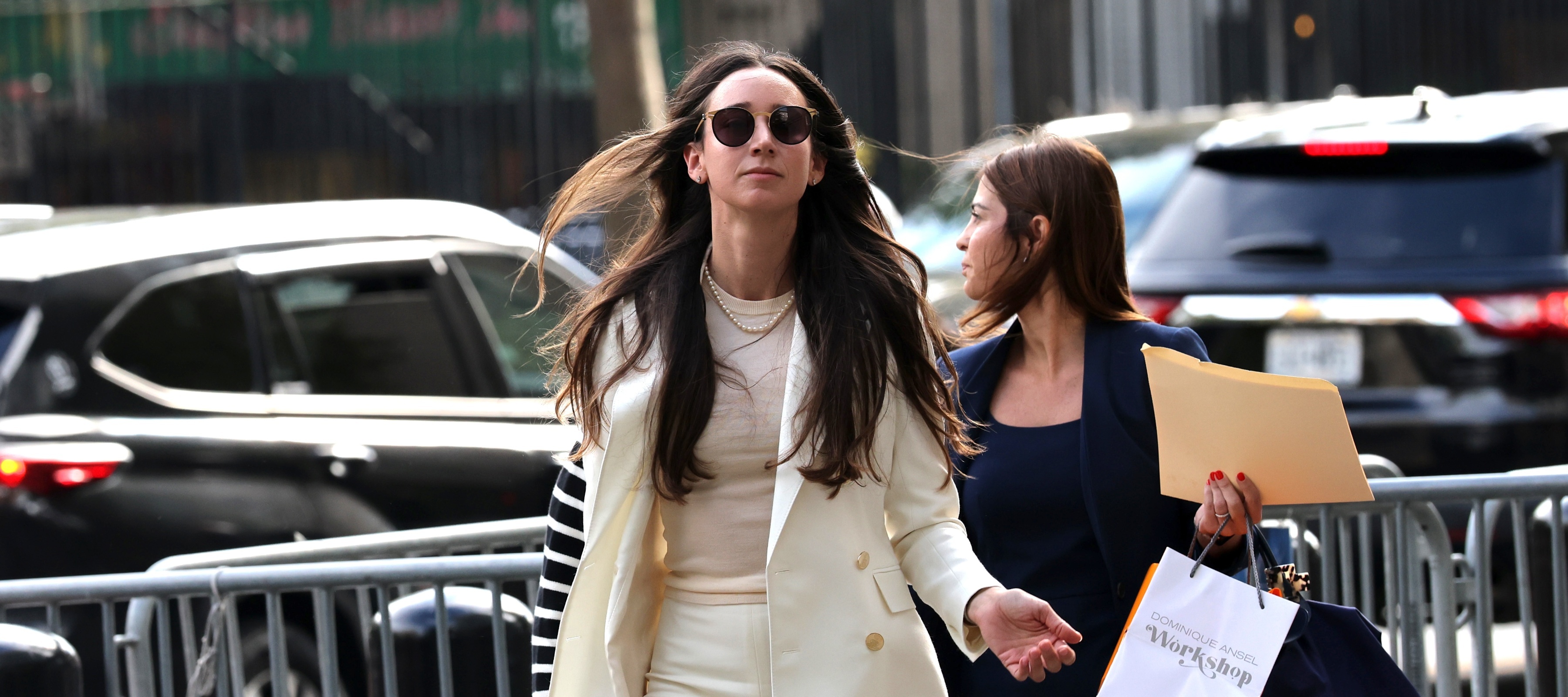 Charlie Javice arrives at court with a woman next to her holding a shopping bag