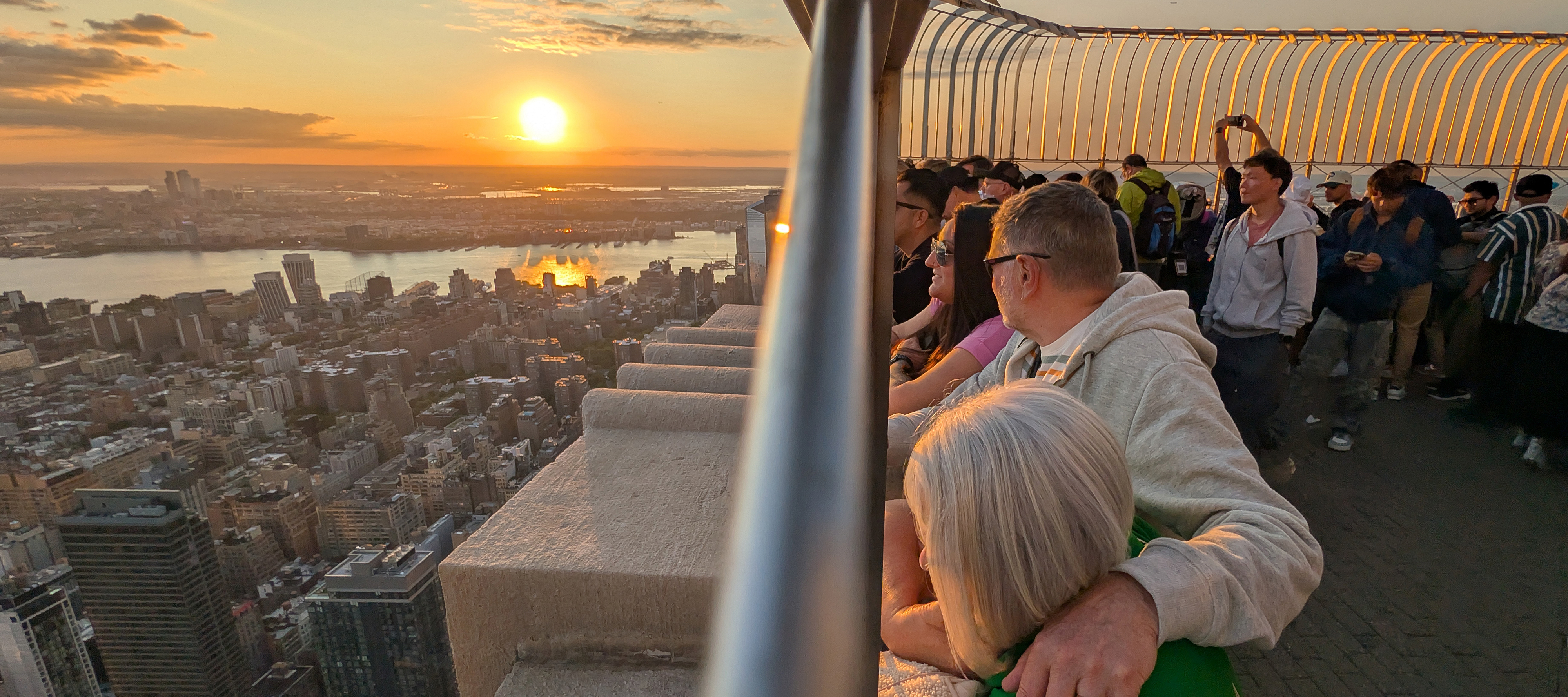 People watch the sun setting behind Jersey City from the 86th floor of the Empire State Building.
