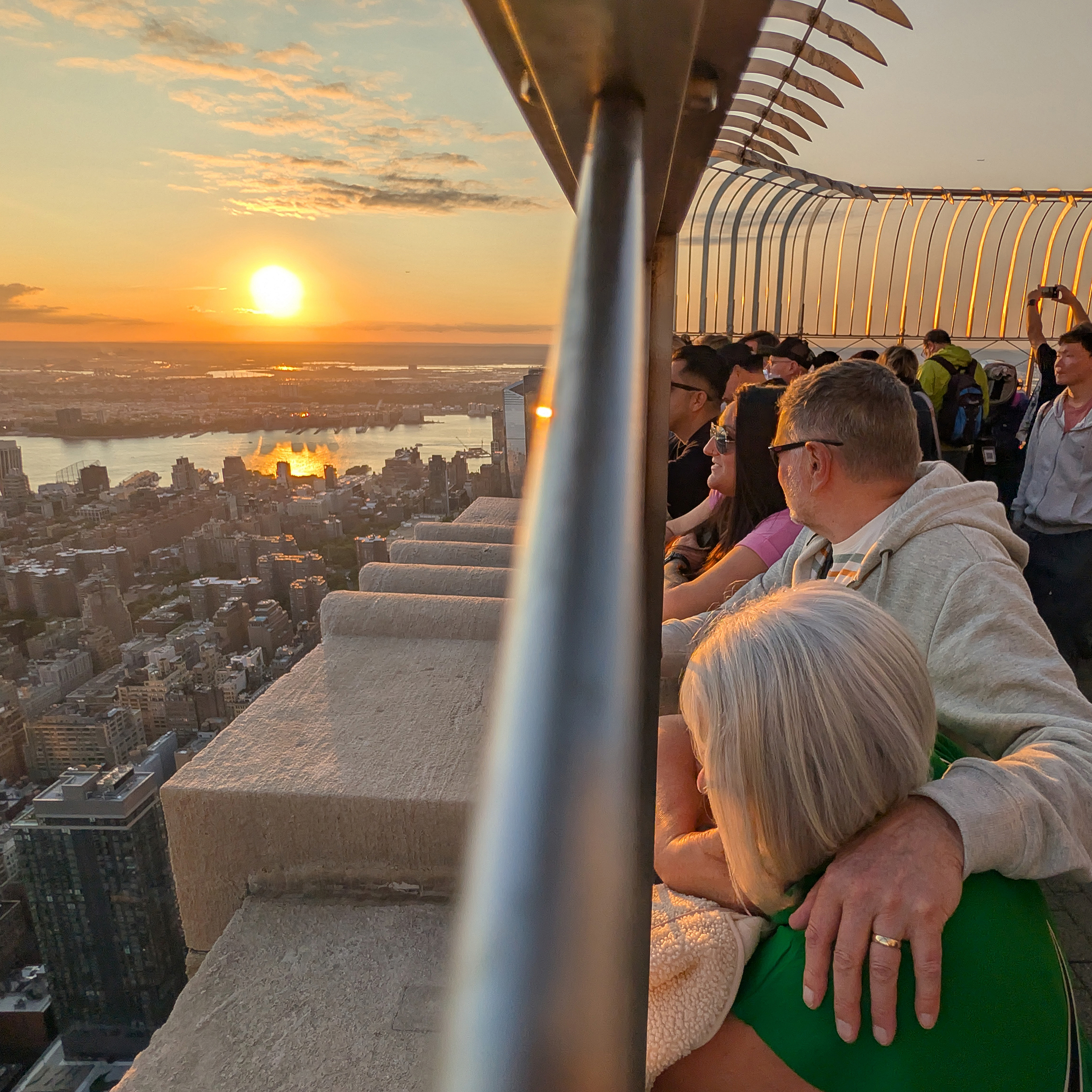 People watch the sun setting behind Jersey City from the 86th floor of the Empire State Building.