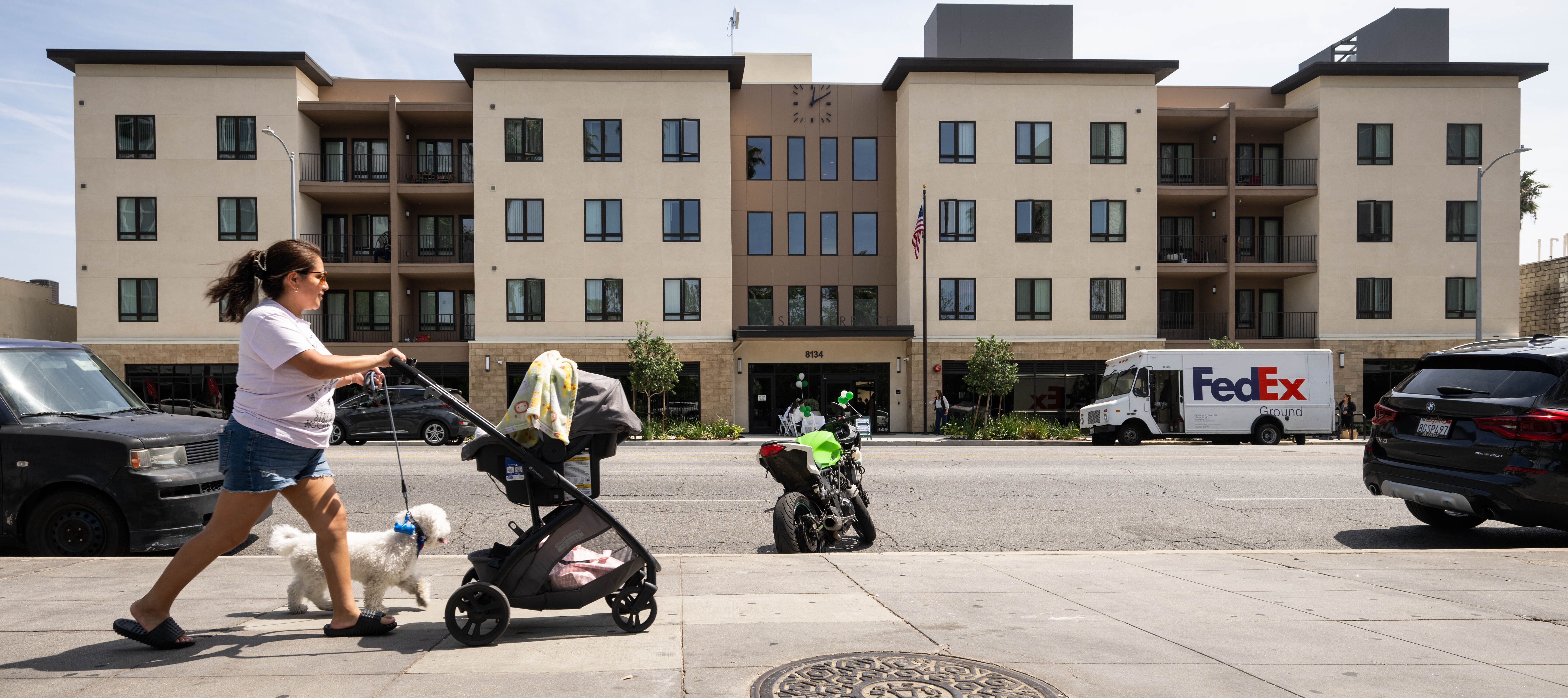 A woman passes a newly constructed affordable houseing development.