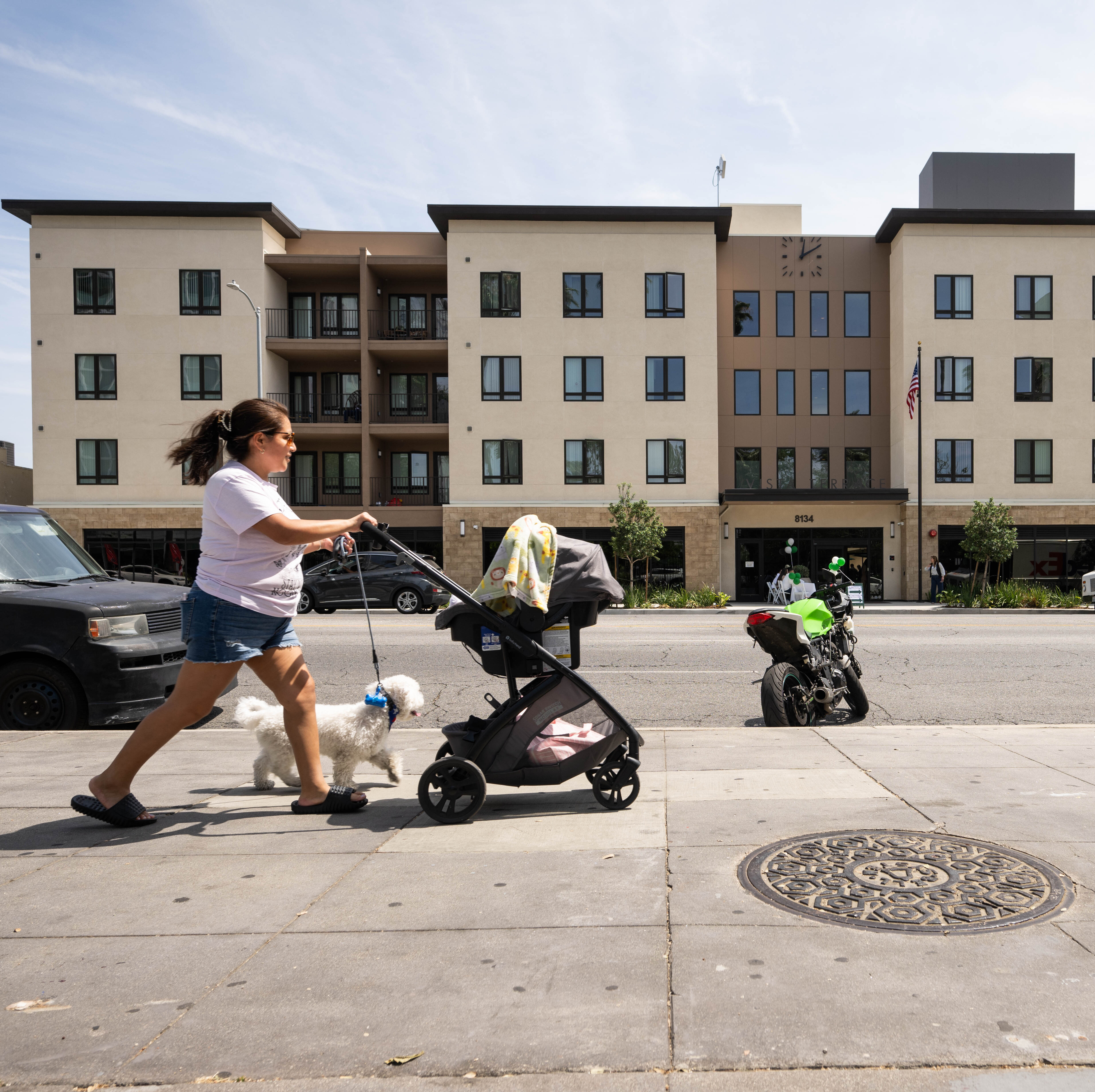A woman passes a newly constructed affordable houseing development.