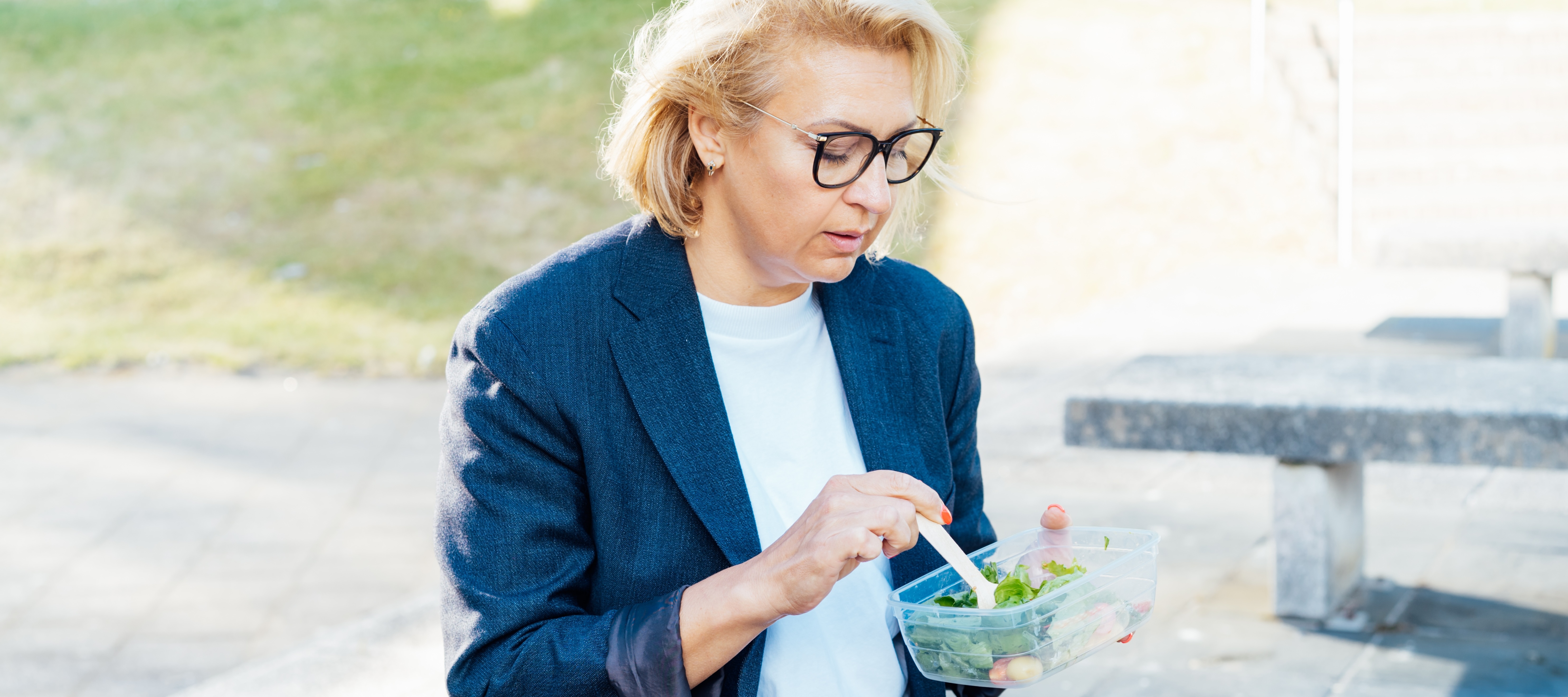 Woman in her 60s eating lunch outside