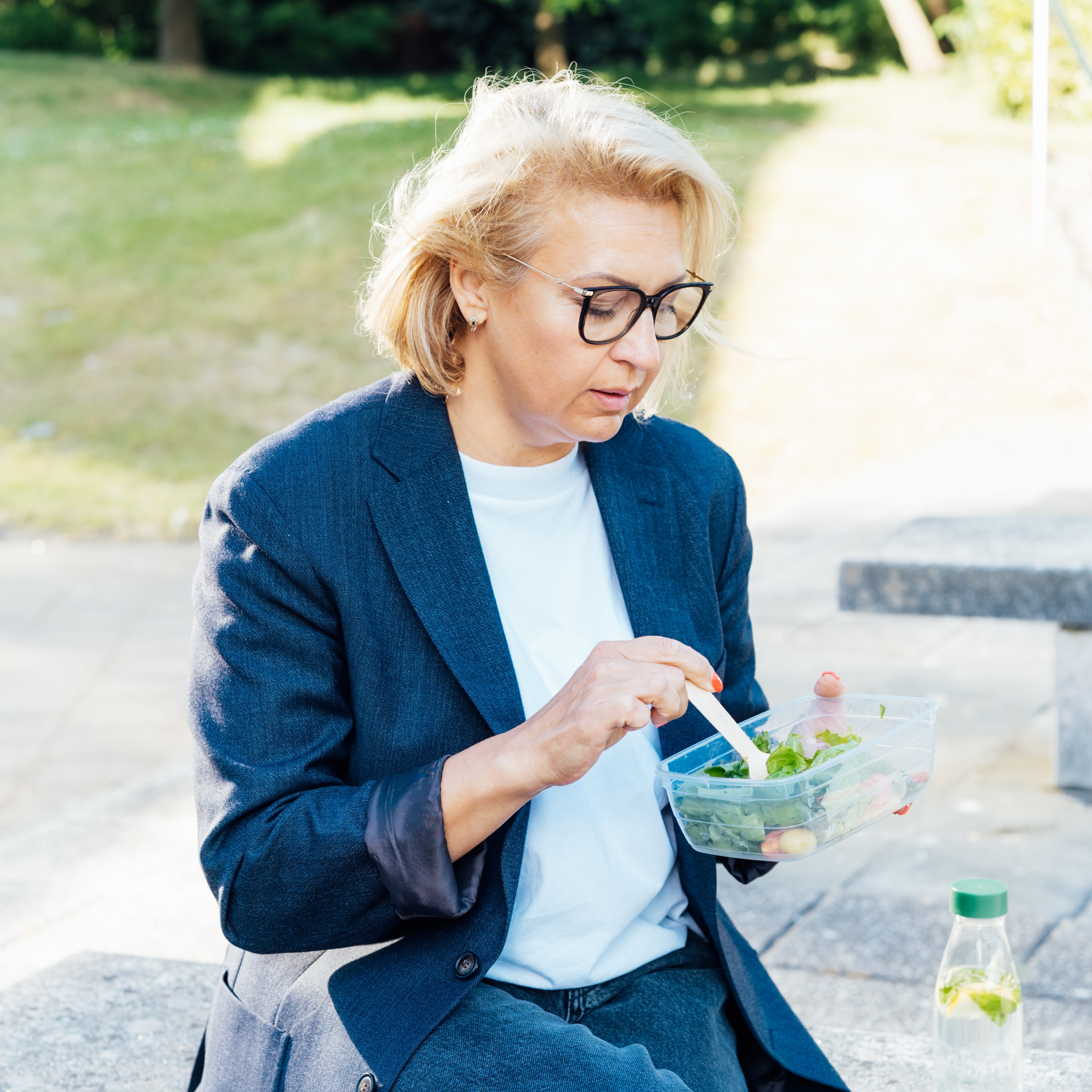 Woman in her 60s eating lunch outside
