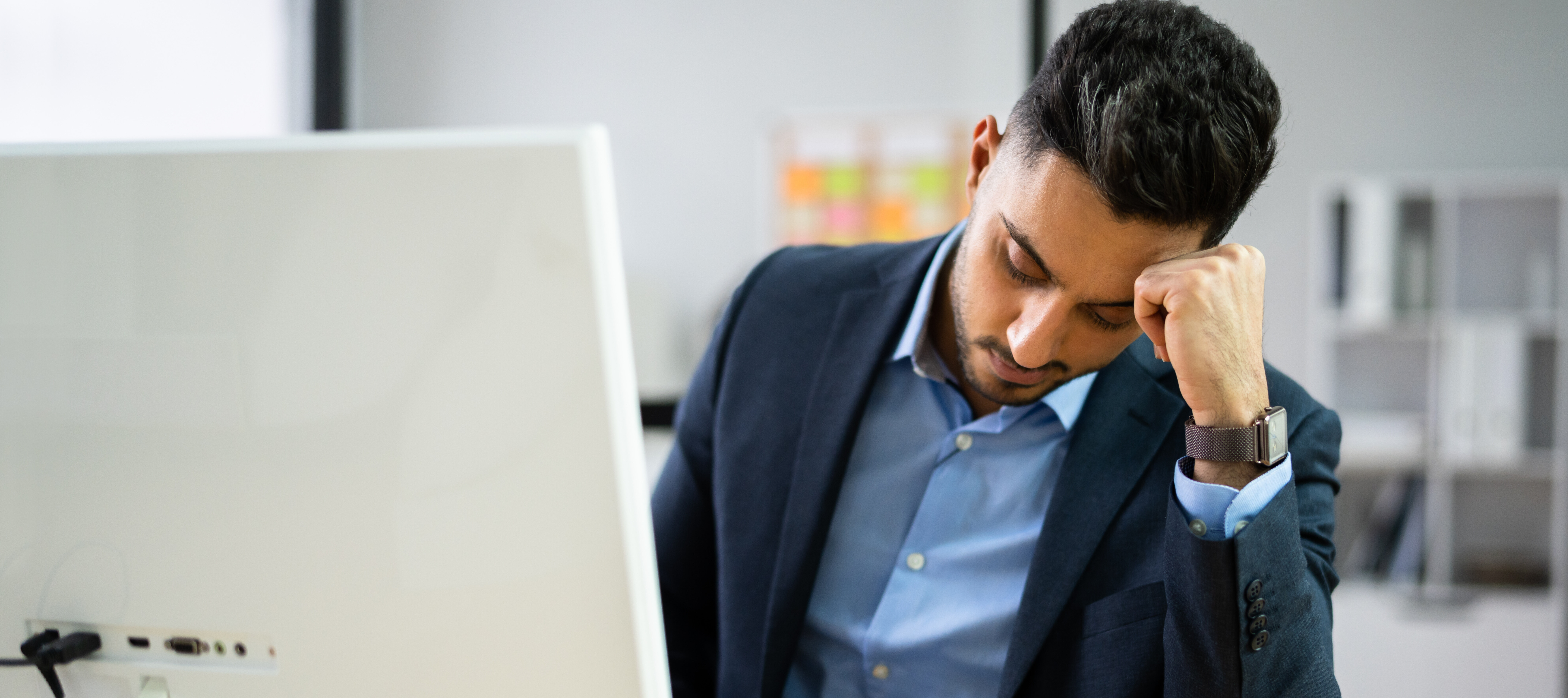 A tired man working at his computer.