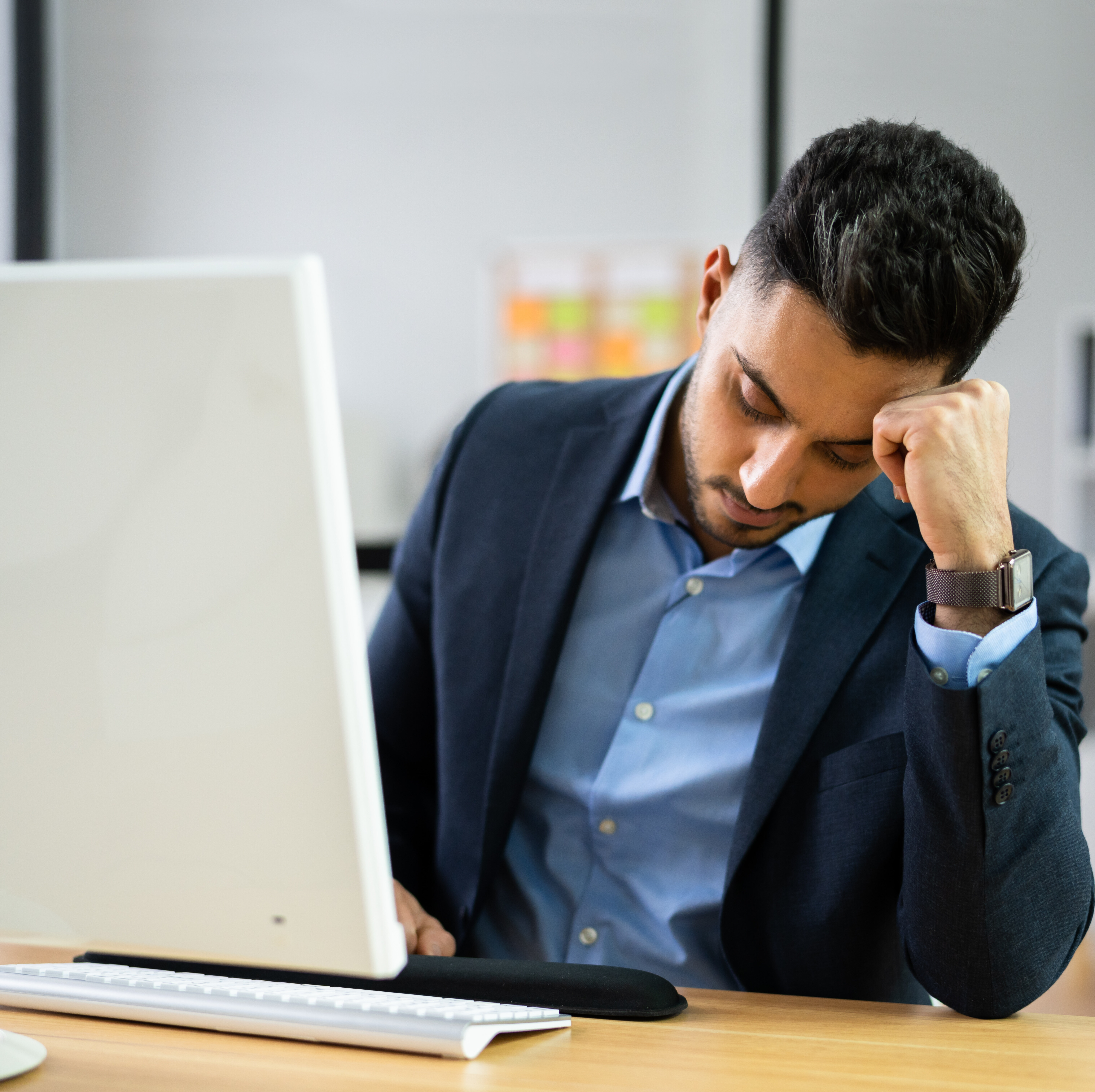 A tired man working at his computer.