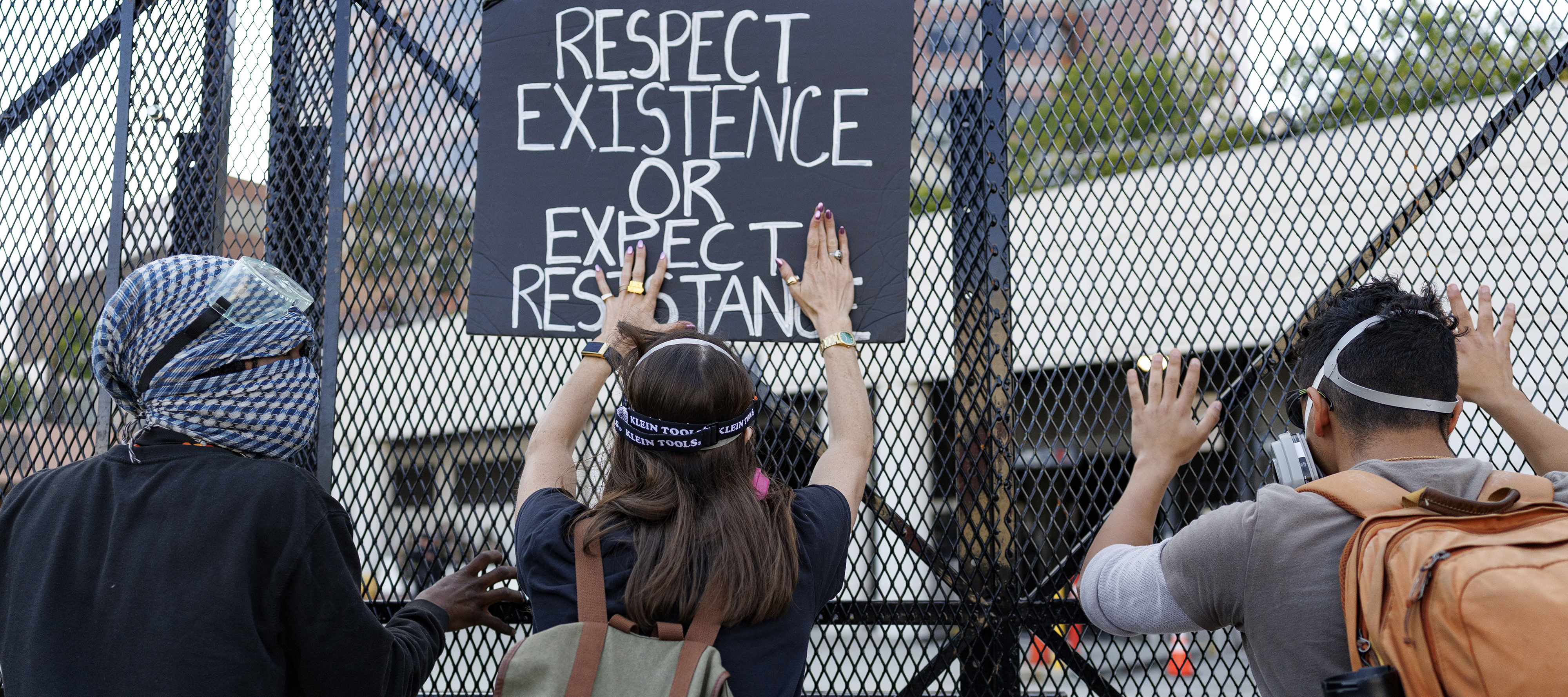 Protesters lean on fencing keeping them out of the Metropolitan Detention Center loading dock after a May Day demonstration in Los Angeles.