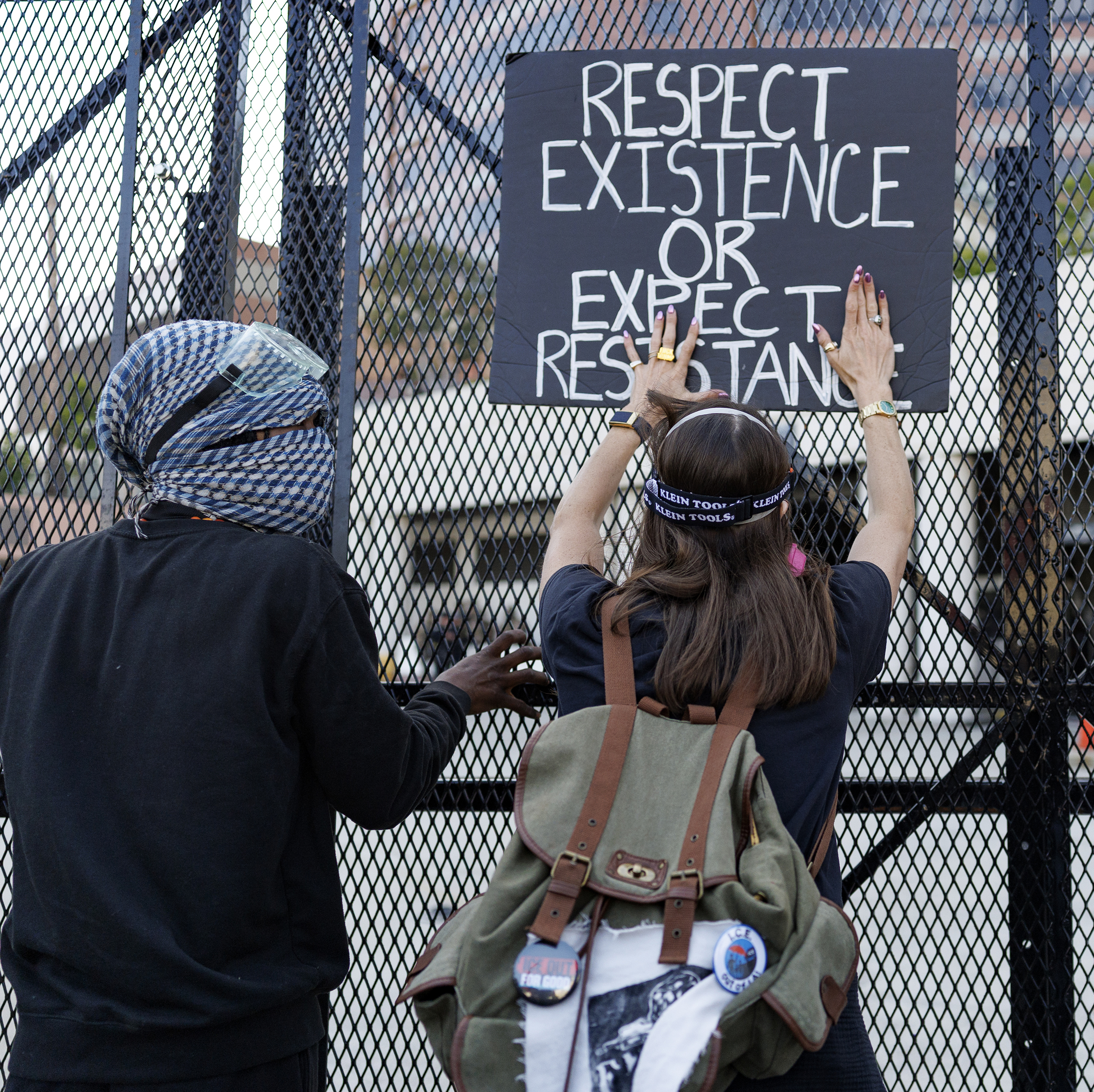 Protesters lean on fencing keeping them out of the Metropolitan Detention Center loading dock after a May Day demonstration in Los Angeles.
