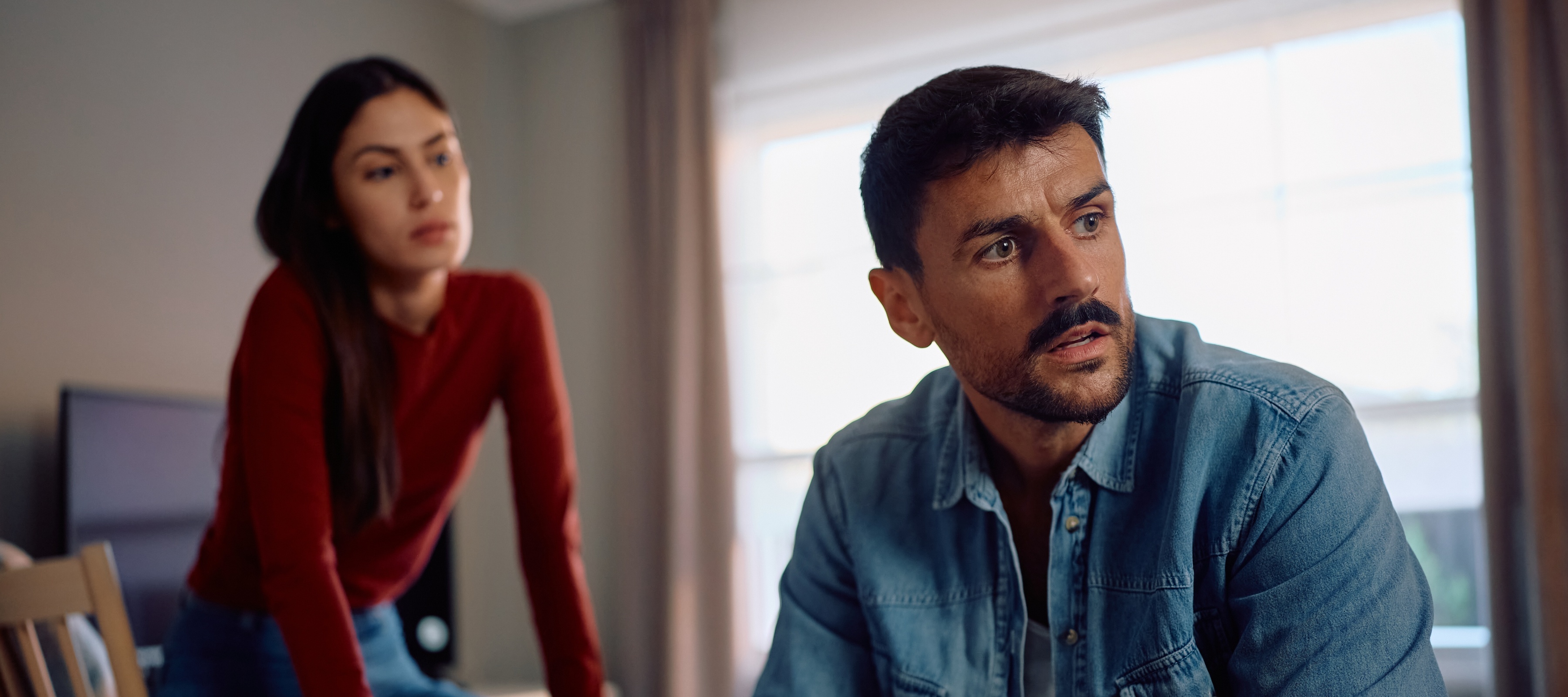 A man looking concerned with a woman looking over his shoulder
