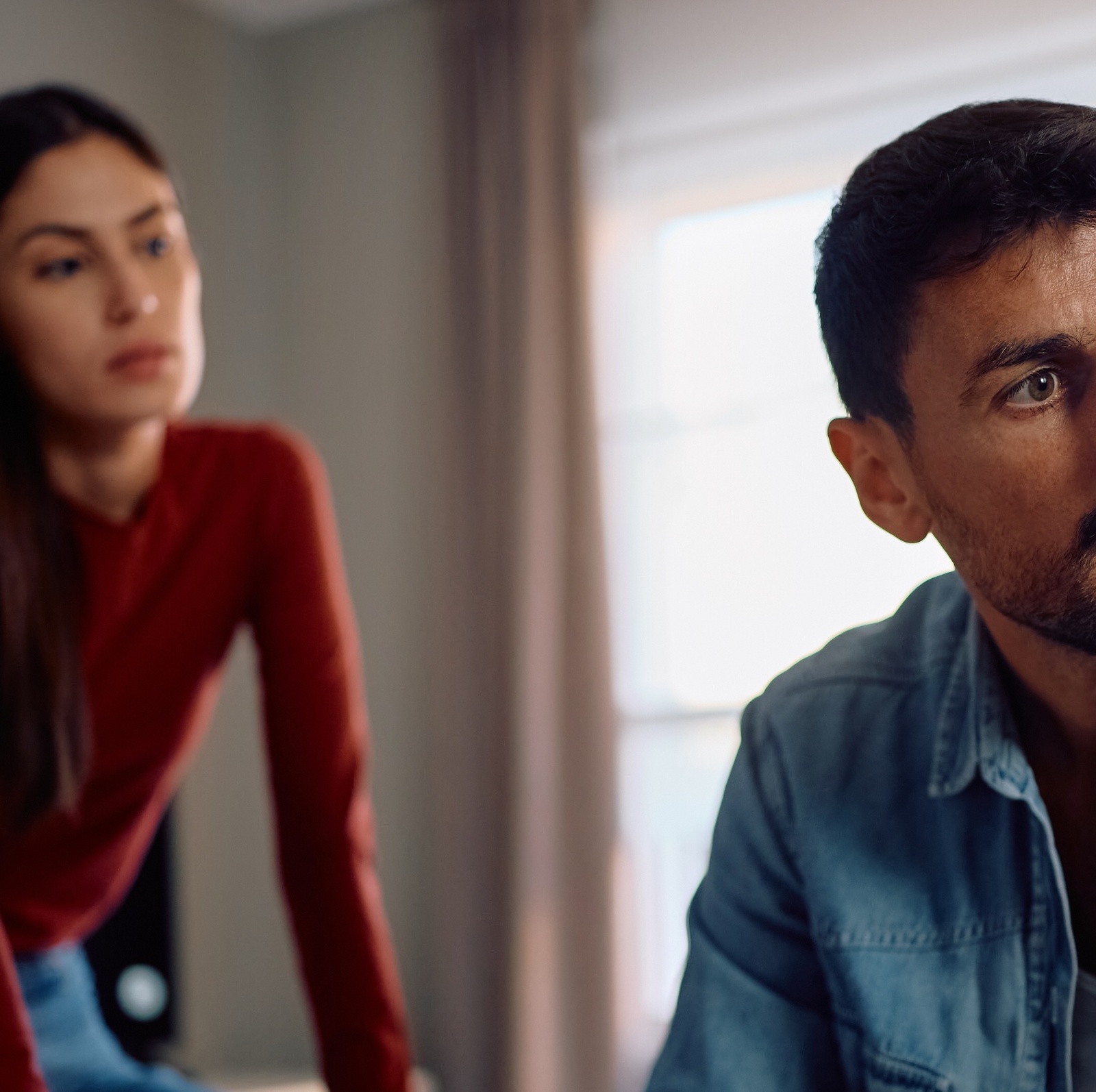 A man looking concerned with a woman looking over his shoulder