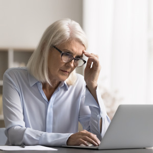 An older woman looking at her computer.