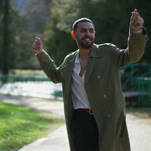 A man dances while ambling about on a park pathway.