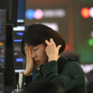 A currency dealer reacts as she monitors exchange rates as the South Korean stock exchange tumbles in fear of an AI bubble pop.