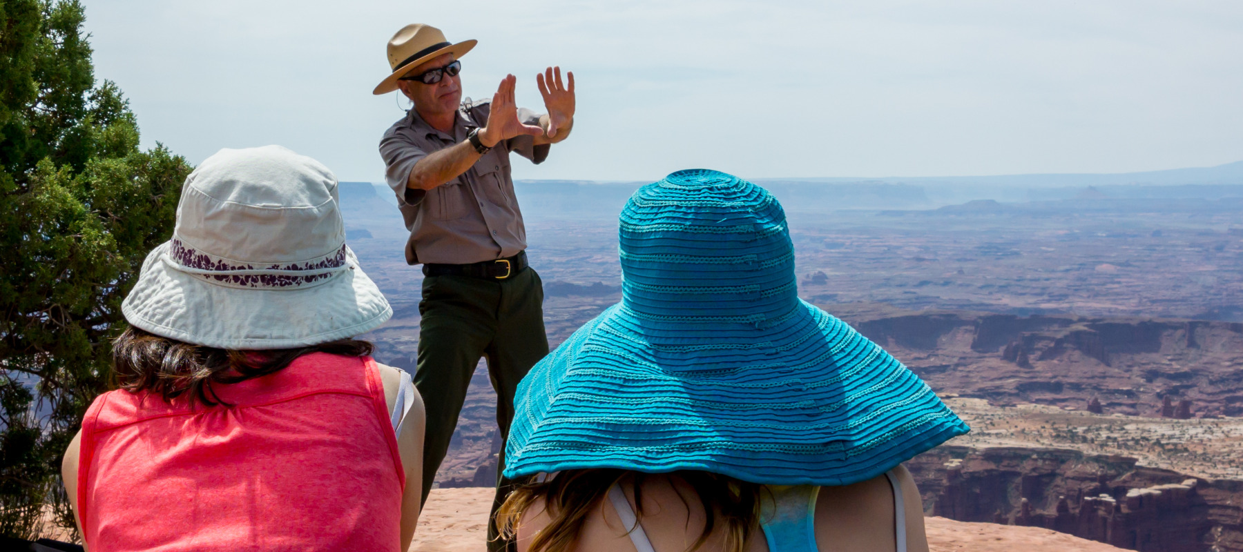A park ranger takes two tourists on a tour.