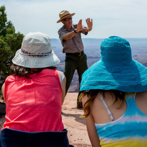 A park ranger takes two tourists on a tour.