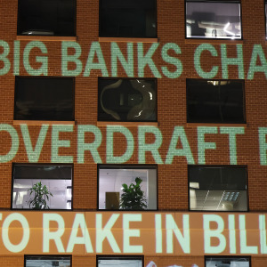 Government Watchdog Accountable.US projects a graphic onto the Consumer Bankers Association HQ to highlight alleged big bank profiteering via overdraft junk fees.