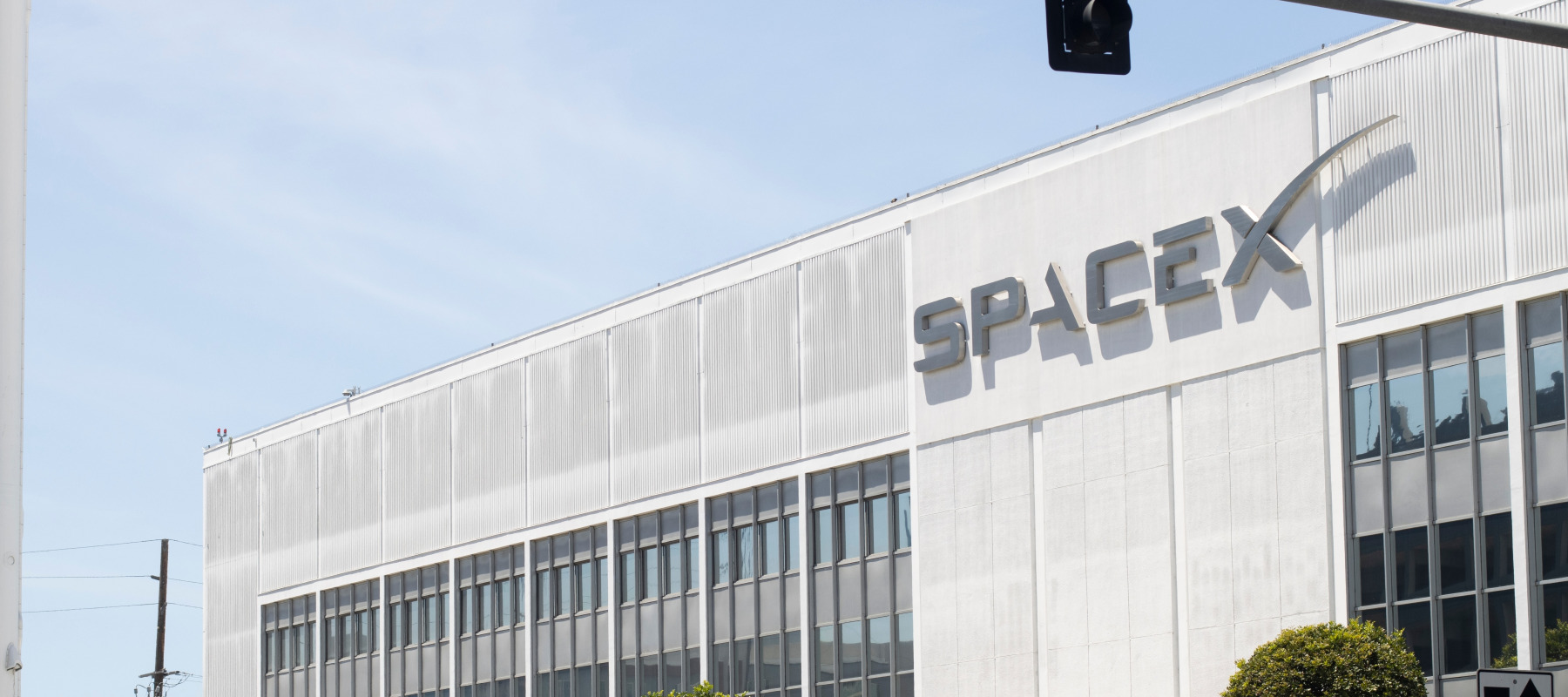 Exterior view of the SpaceX headquarters with recovered Falcon 9 rocket booster on display in Hawthorne, California.