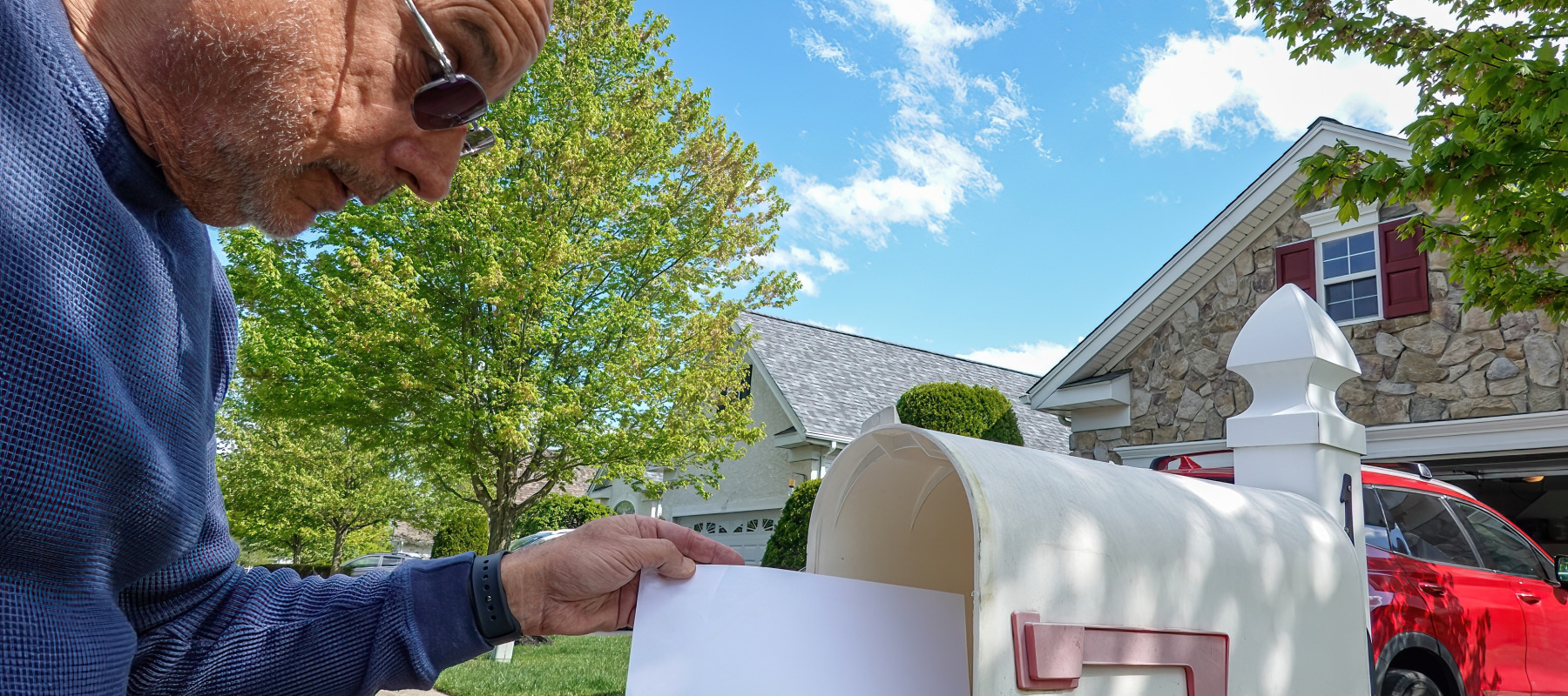 An older man checks his mailbox.
