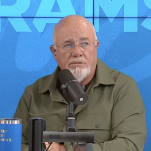 Dave Ramsey is seen behind the desk on his show The Ramsey Show giving advice about car insurance deductibles.
