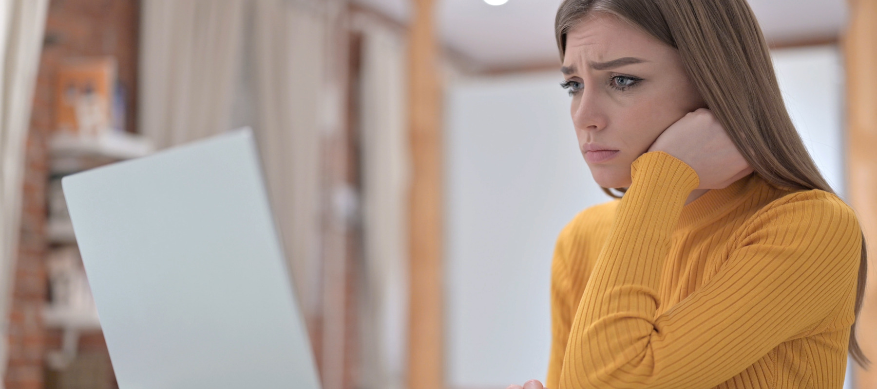 A concerned woman looking at her computer.