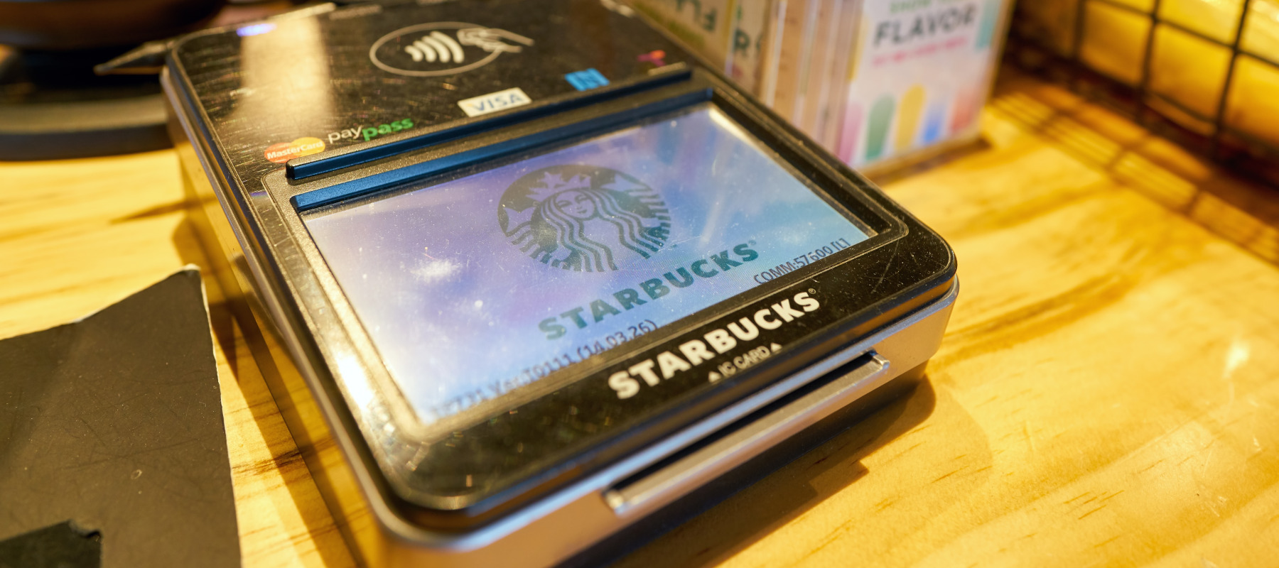 A close up of a payment device on a counter in a Starbucks coffee shop.