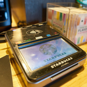 A close up of a payment device on a counter in a Starbucks coffee shop.